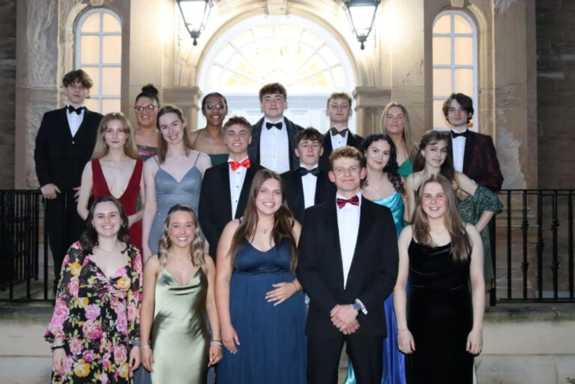 Prefects stood together outside building in formalwear.