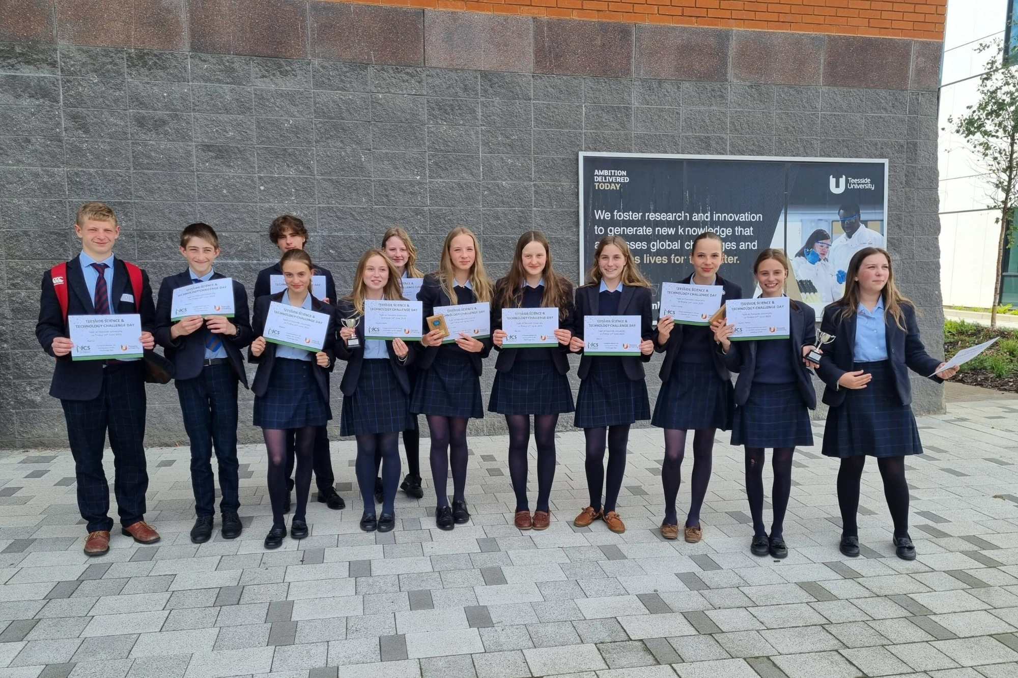 Students holding certificates for the science and technology challenge