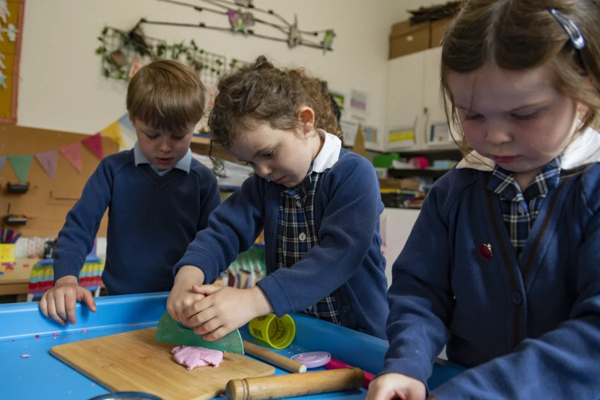 Three Barnard Castle School pupils using their creative skills into creating art work with colourful modelling clay.