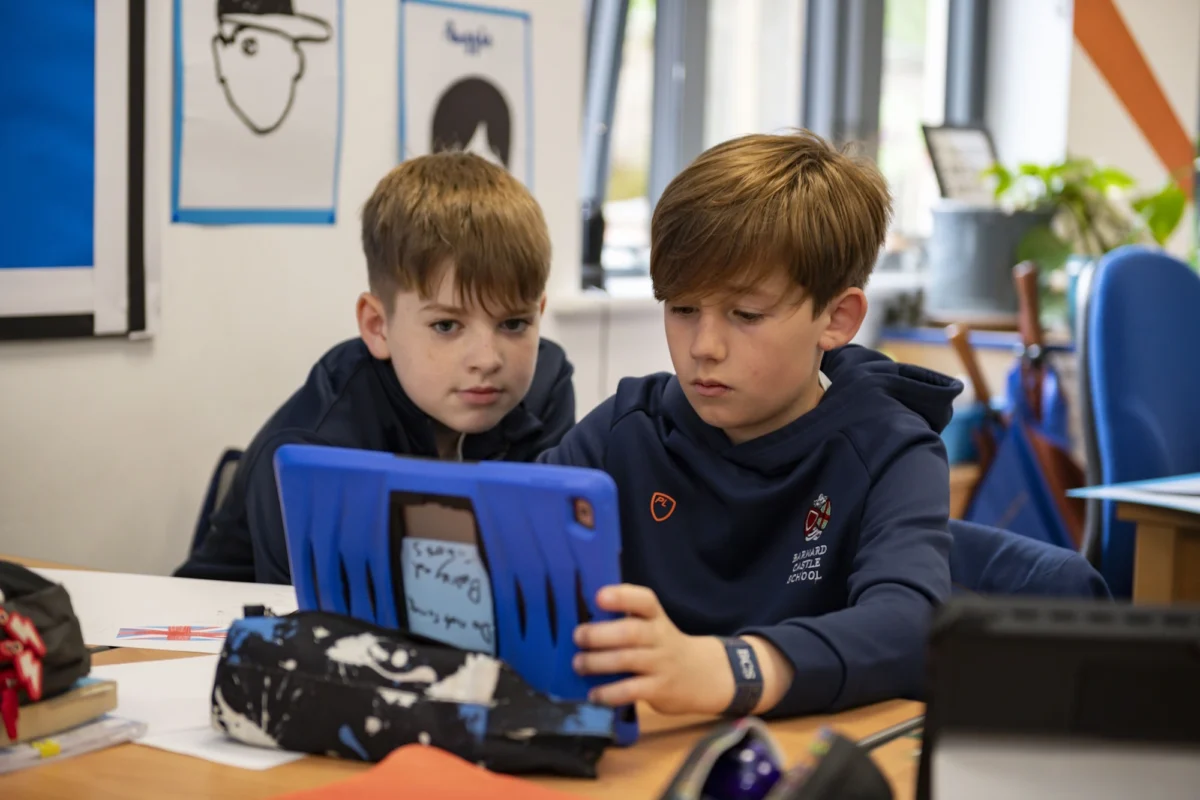 Two Barnard Castle School pupils using an iPad to further enhance their learning in the classroom.