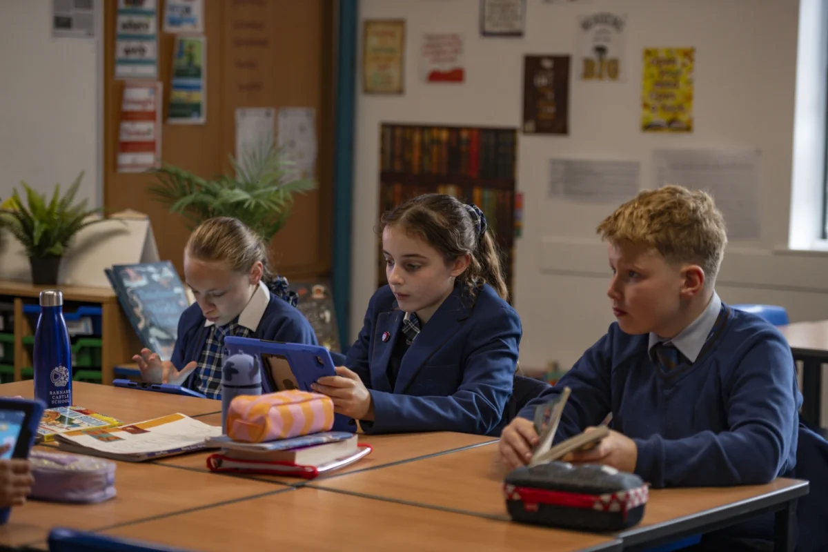 Three Barnard Castle School pupils using iPads to further enhance their learning experience in class.