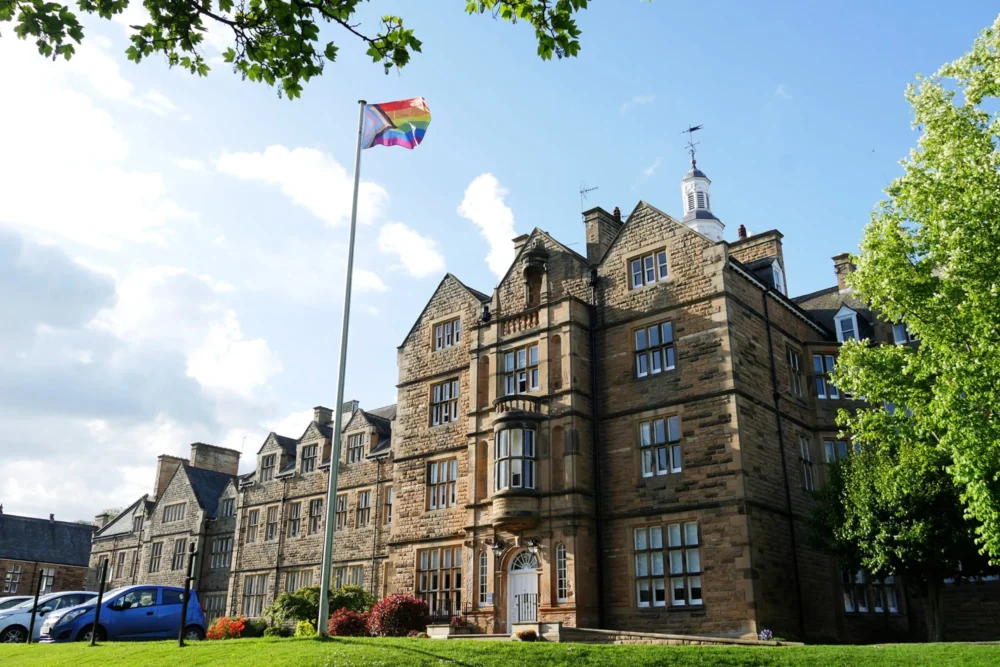 Exterior of Barnard Castle School with a rainbow flag flying.
