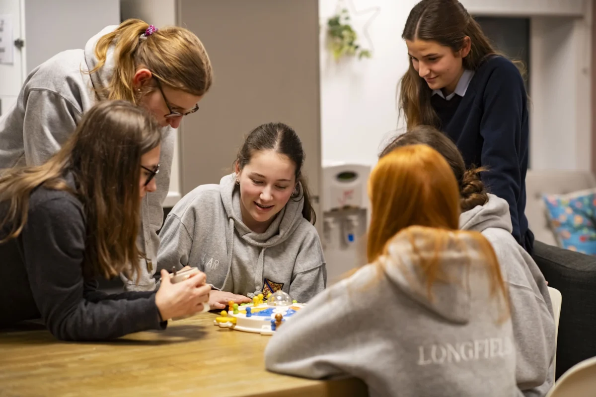 Barnard Castle School boarding pupils sat together playing a board game.