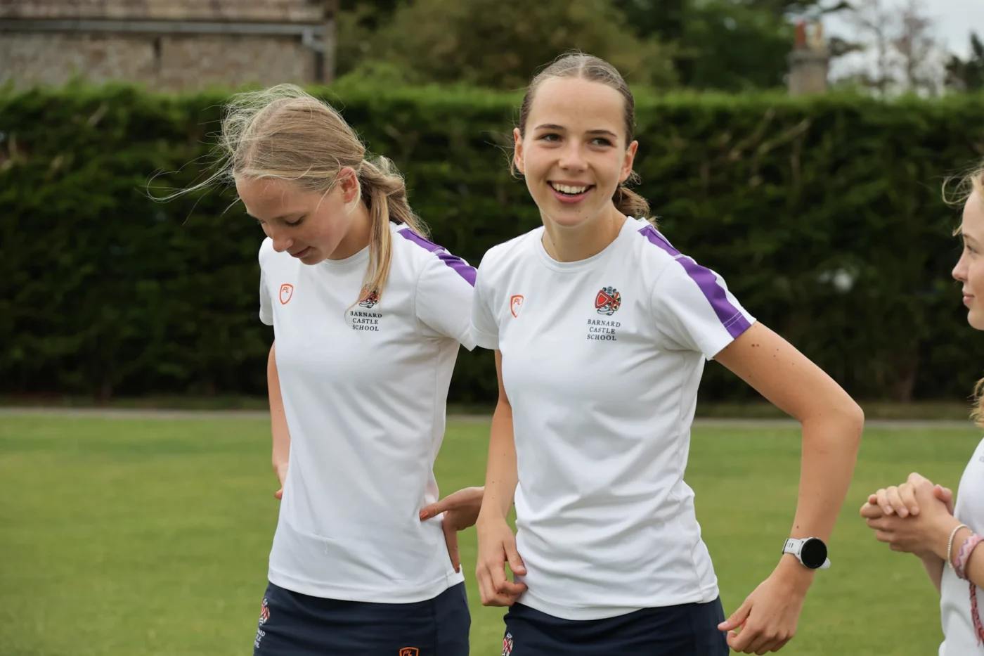 Two students in sports uniform outside at Barney.