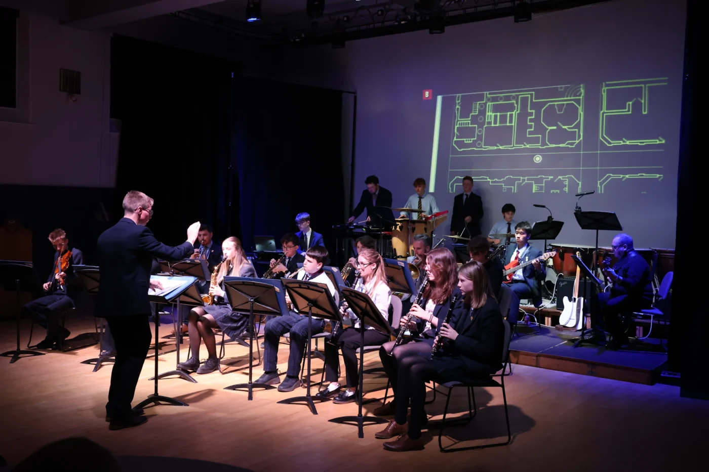 Barnard Castle School pupils performing on stage with a conductor.