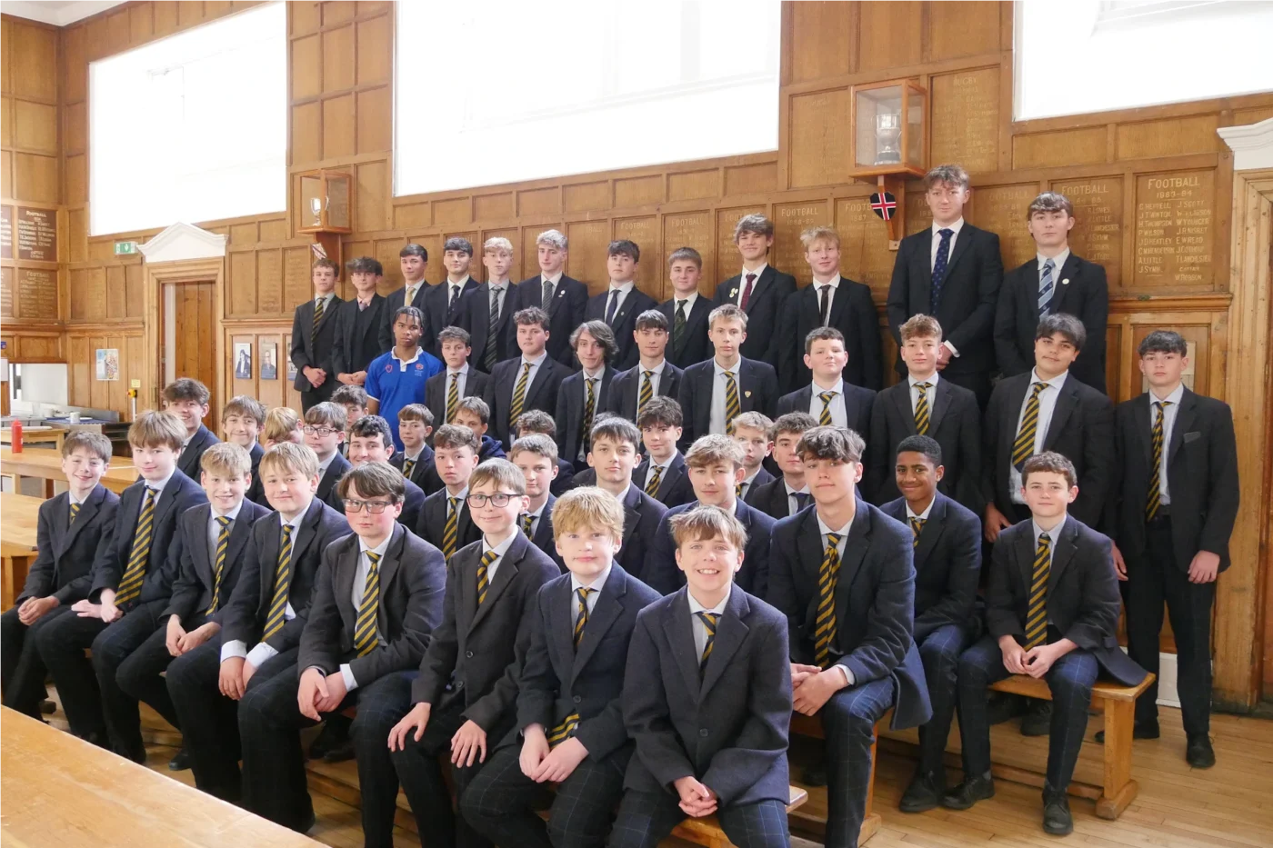 Barnard Castle SChool pupils sitting on a bench in the dining hall.