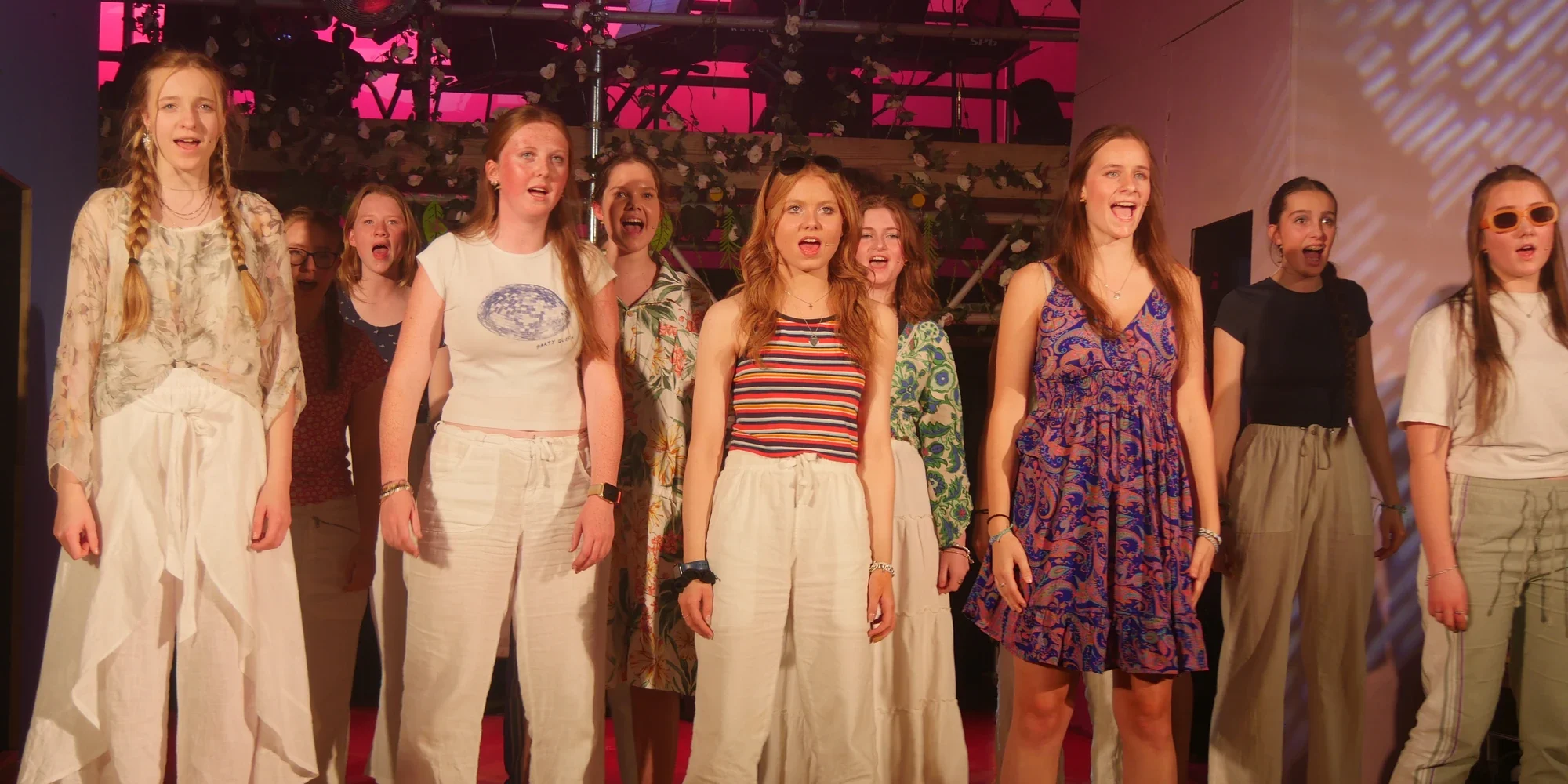 Girls on stage performing and singing.