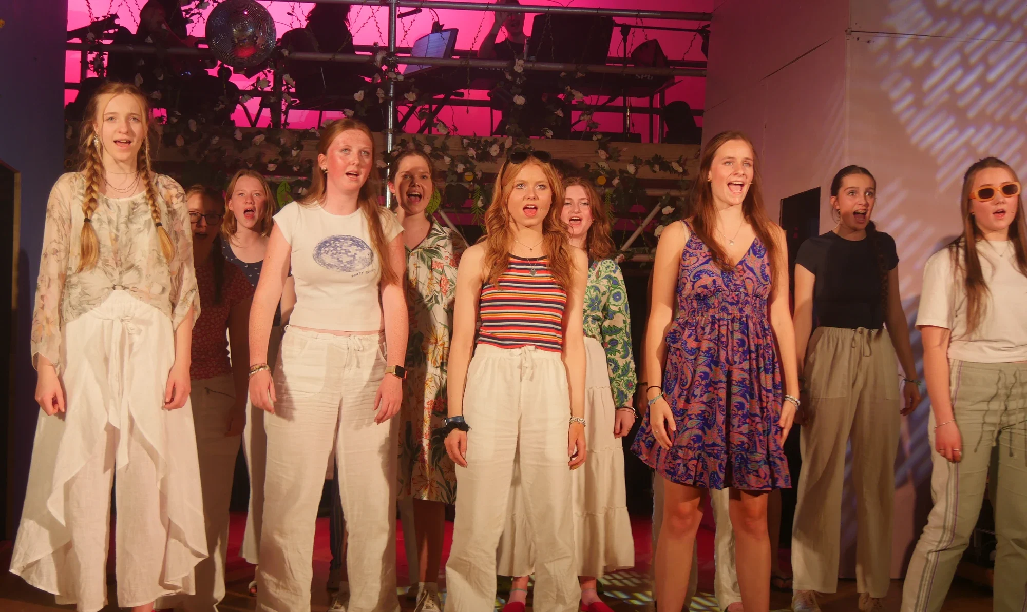 Girls on stage performing and singing.