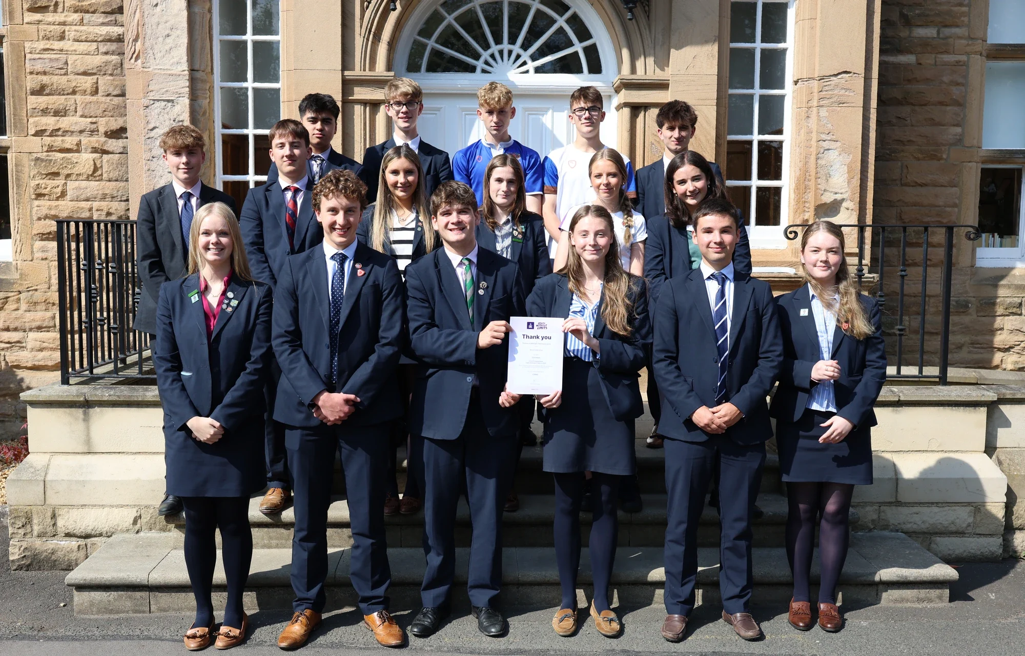 Students stood outside school celebrating completion of Duke of Edinburgh Award.
