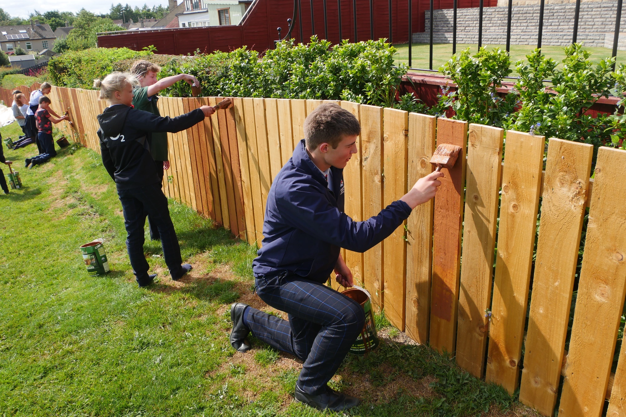 Students painting fence.
