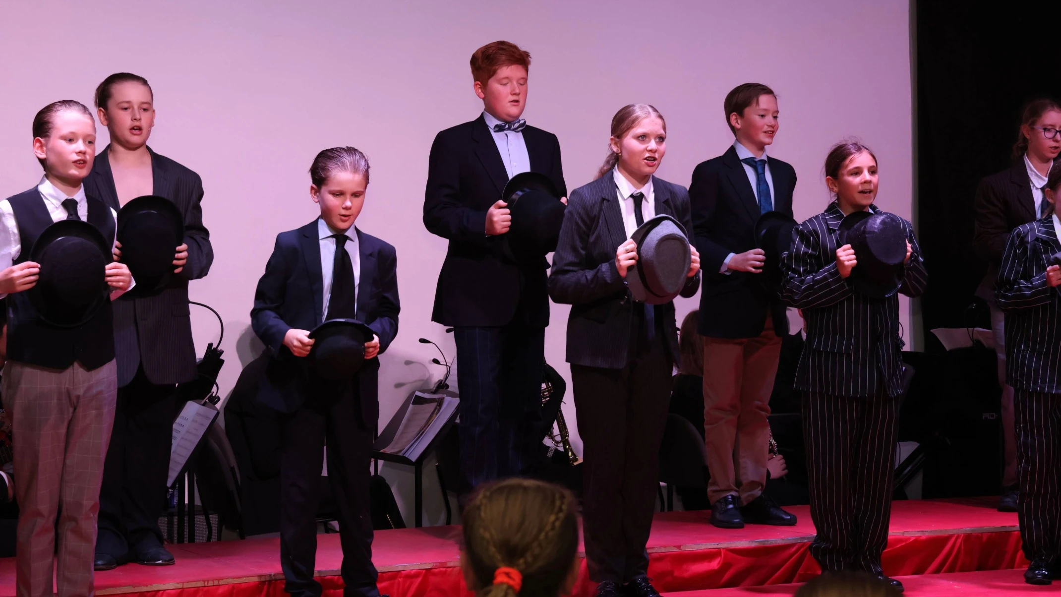 Students wearing suits and ties, singing.
