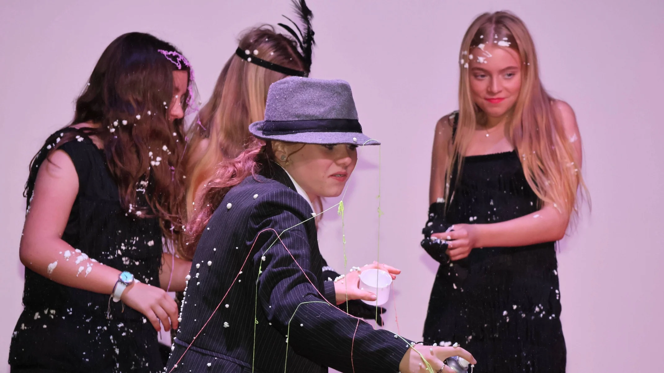 Students covered in silly string and cream during a performance of Bugsy Malone.
