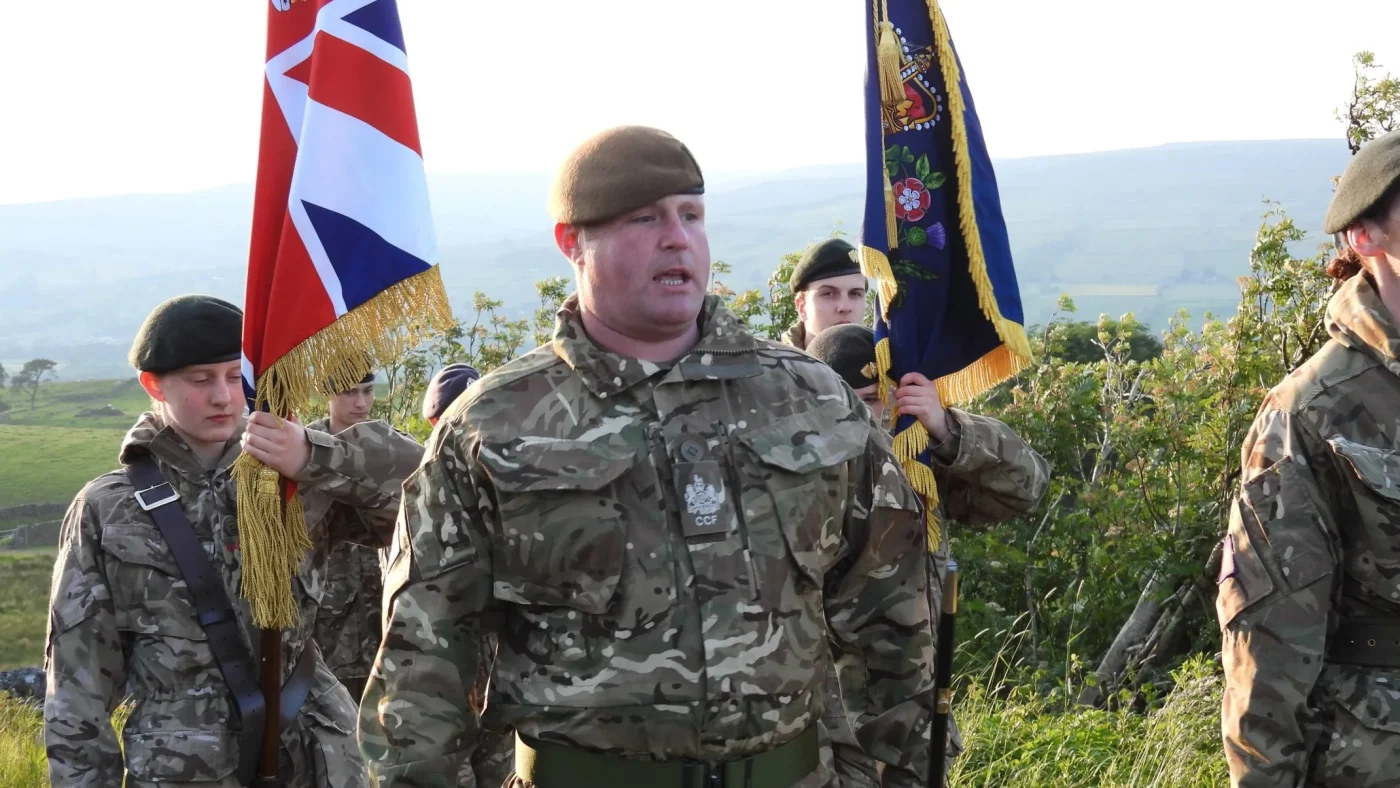 People of various ages in military uniform walking.