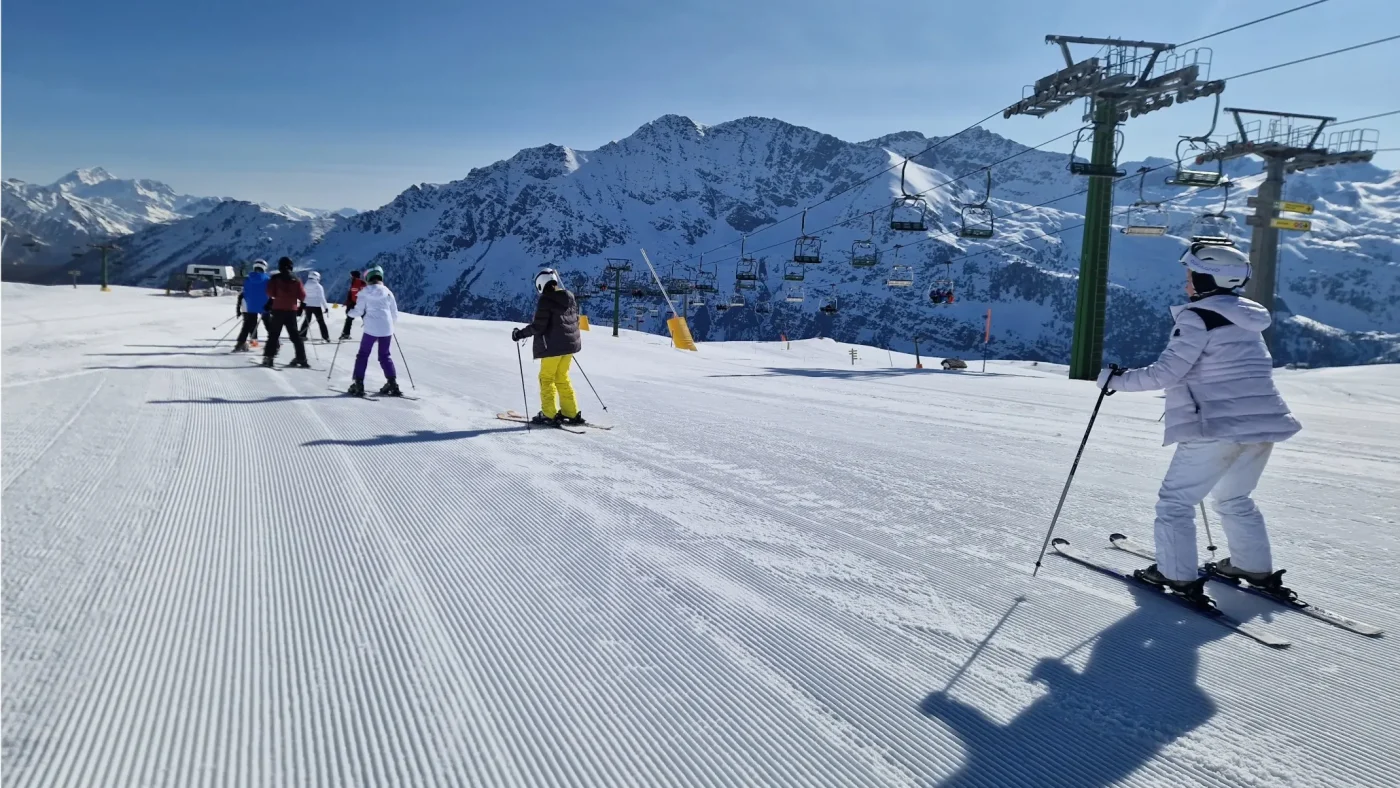 A group of Barney students skiing down a snow-covered hill.