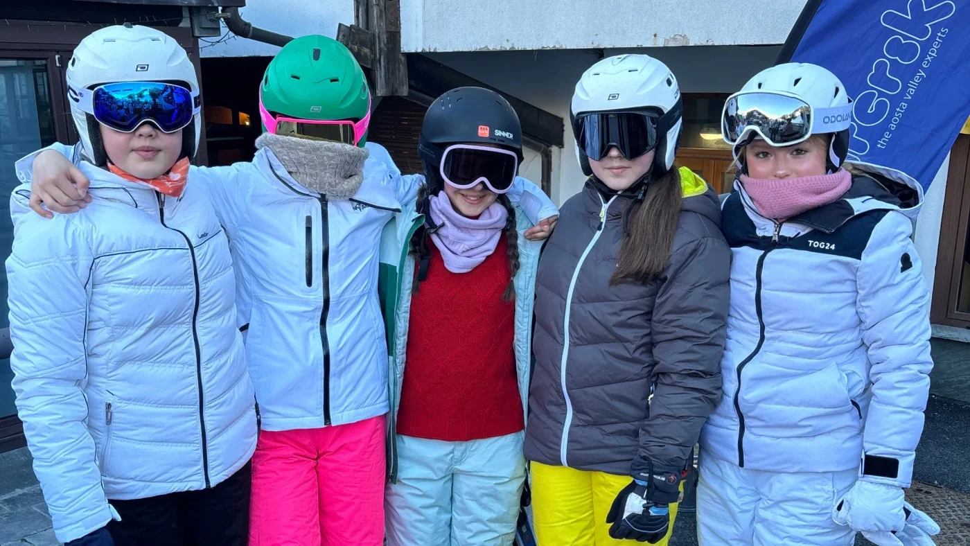 A group of girls from Barney standing together in their ski gear.