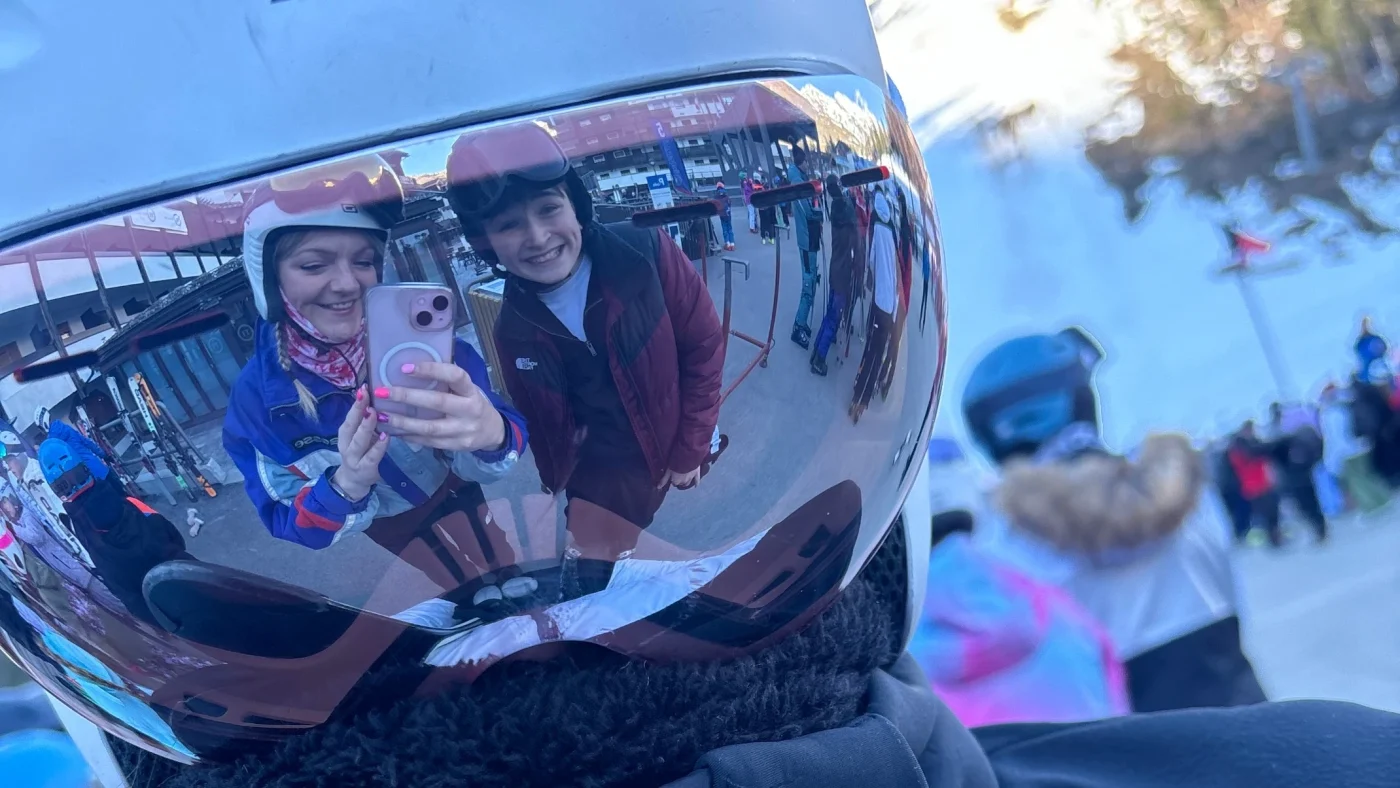 Two smiling Barney students reflected in a ski visor.