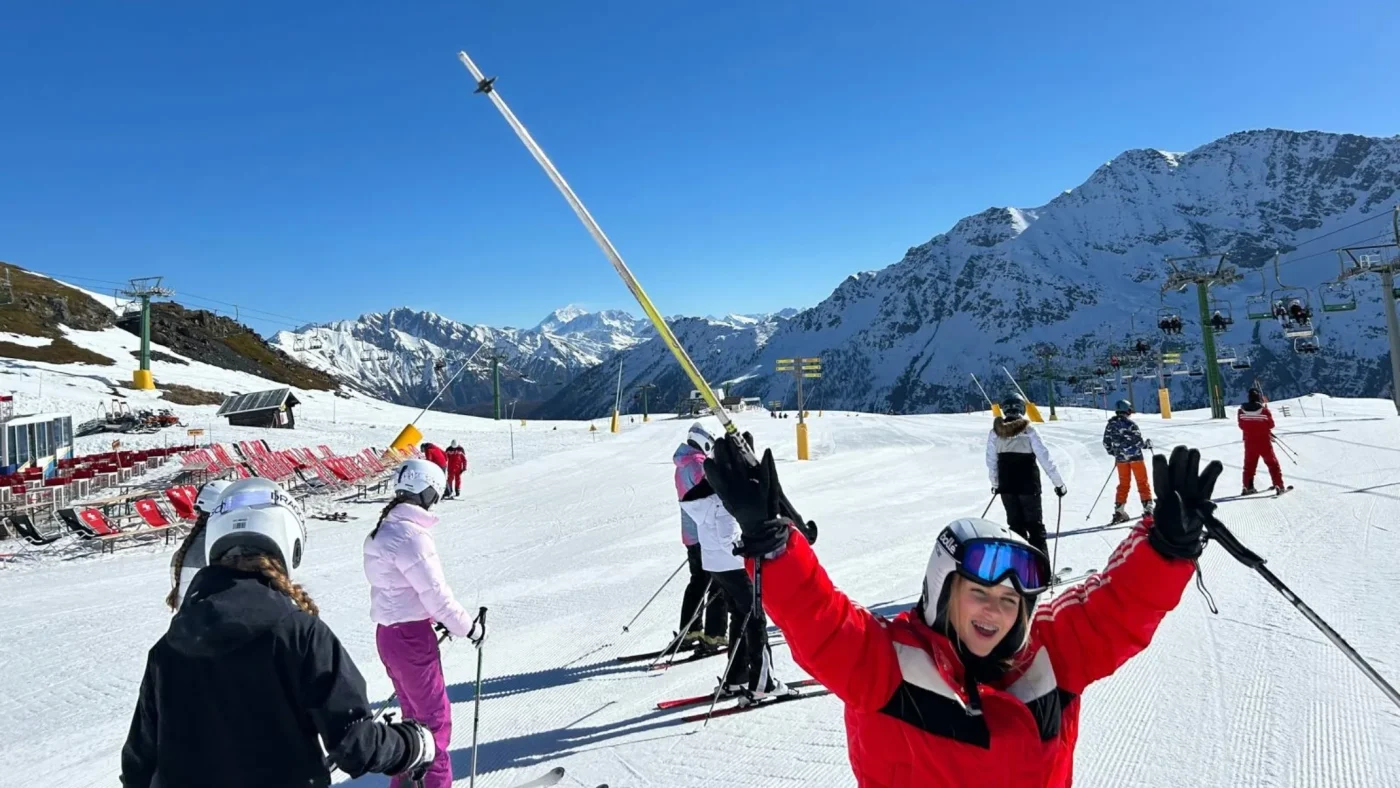 A Barney student sticking her ski poles in the air.