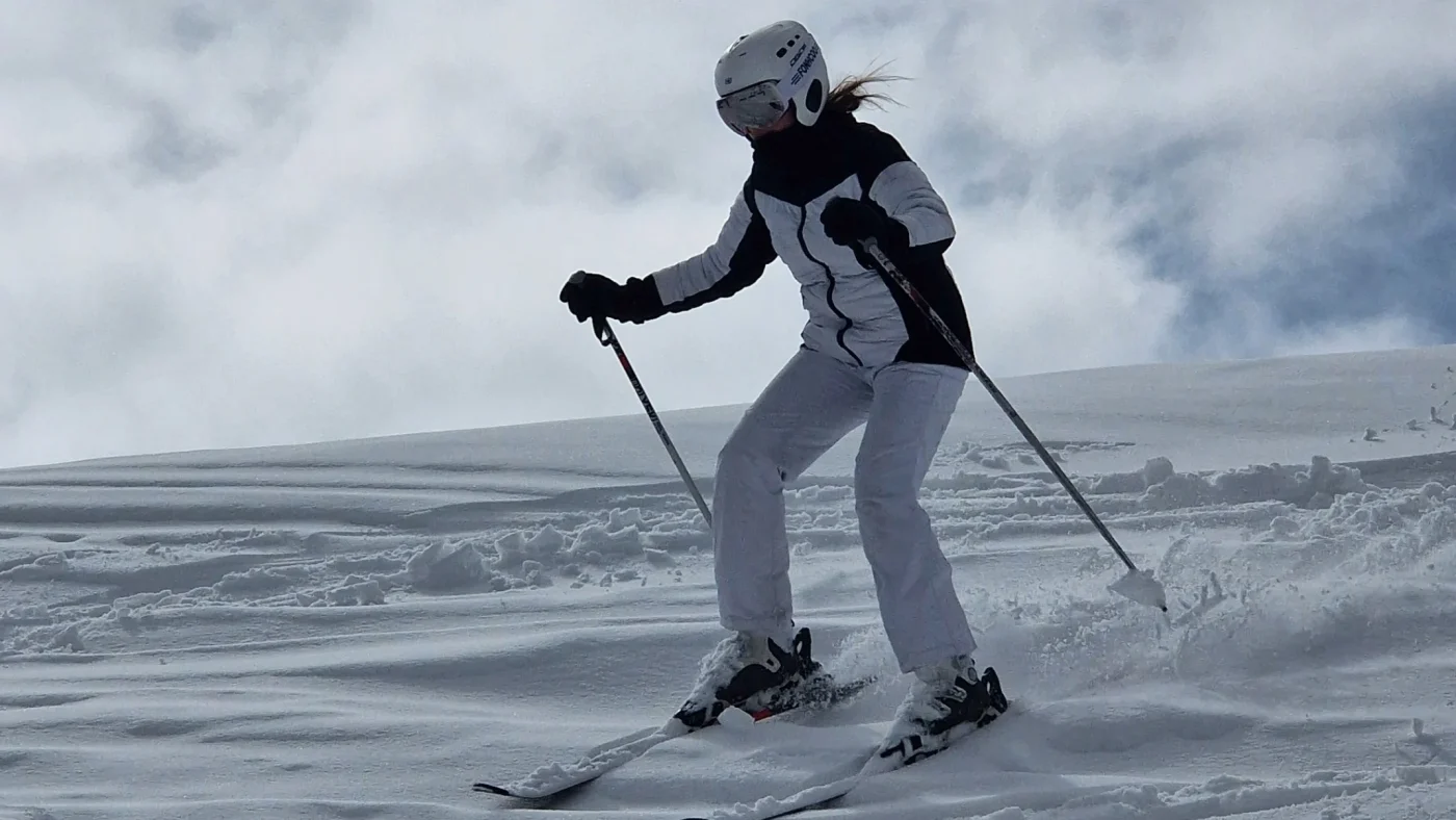 A Barney student skiing down a snowy hill.