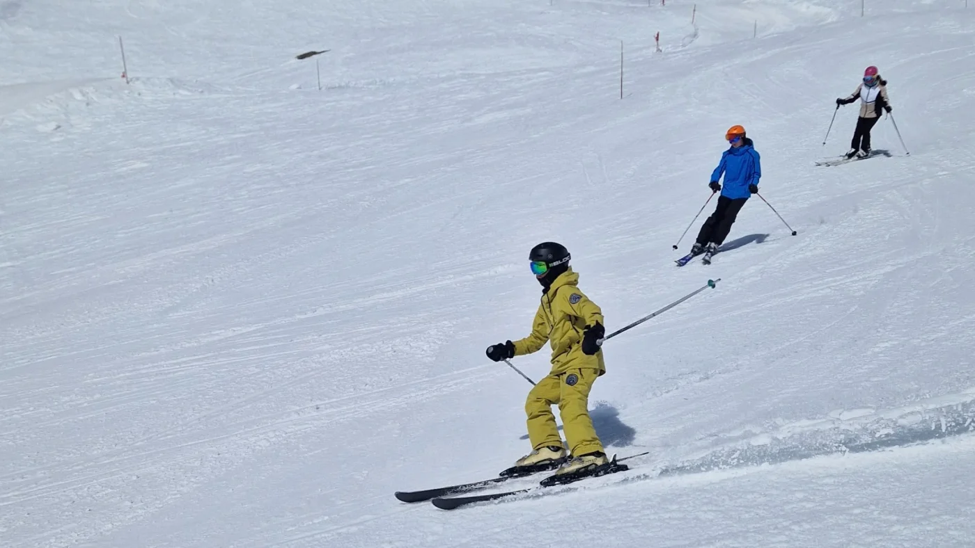 Barney students skiing down a hill together.