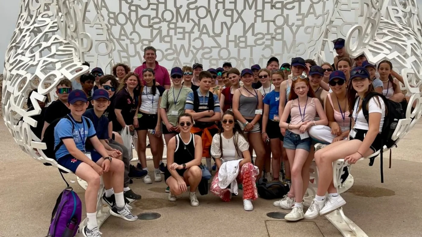 A group of Barney students sitting together on a large sculpture.