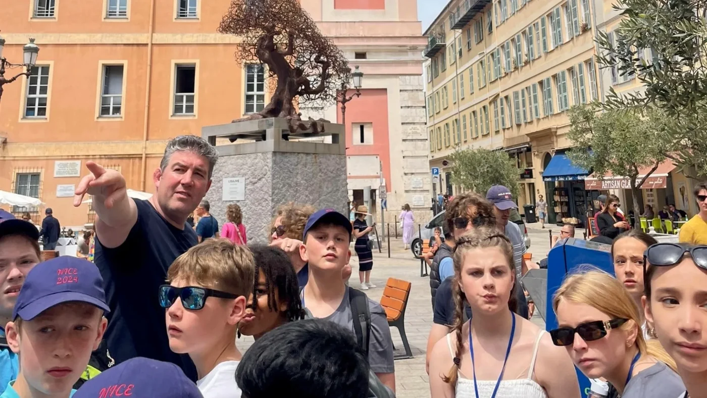 A teacher guides a group of Barney students around.