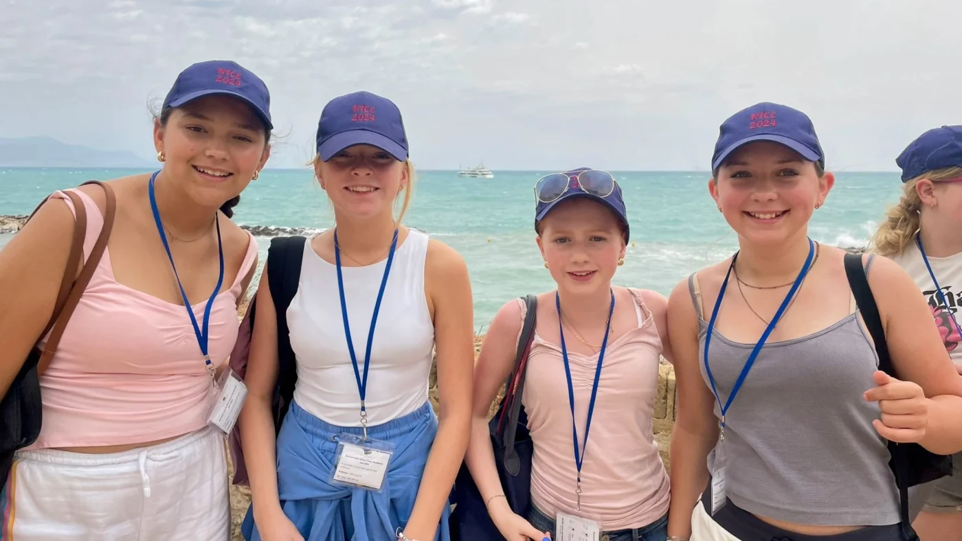 Barney girls standing in front of the ocean.