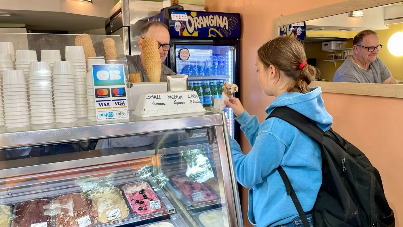 A Barney student buys an ice cream in French.