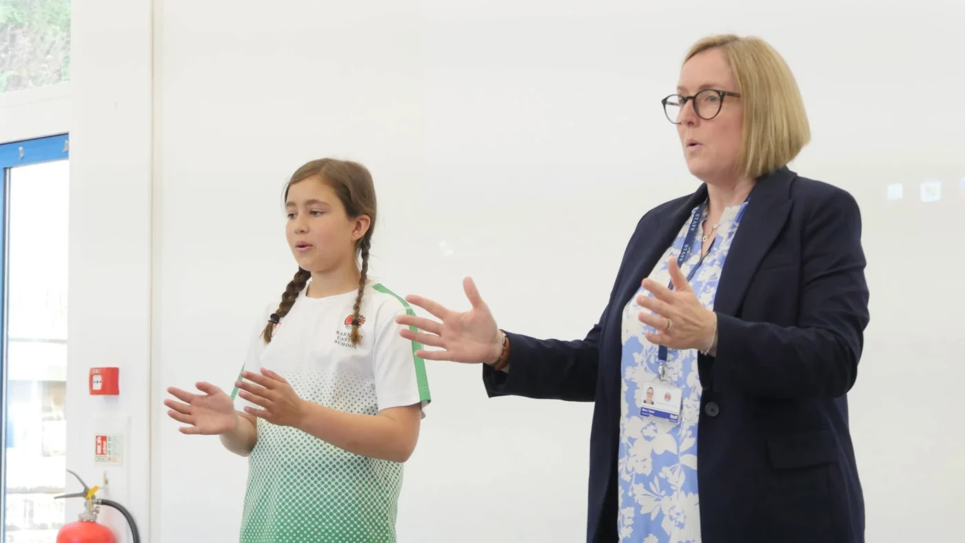 A woman and young girl signing.