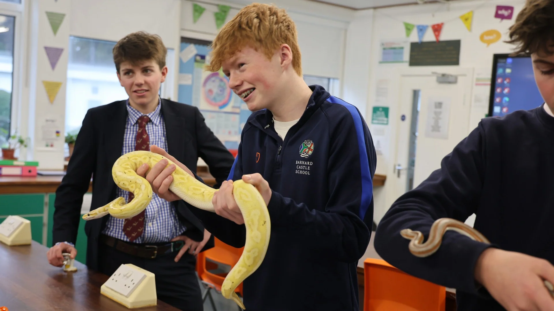 Barney students holding a yellow snake.