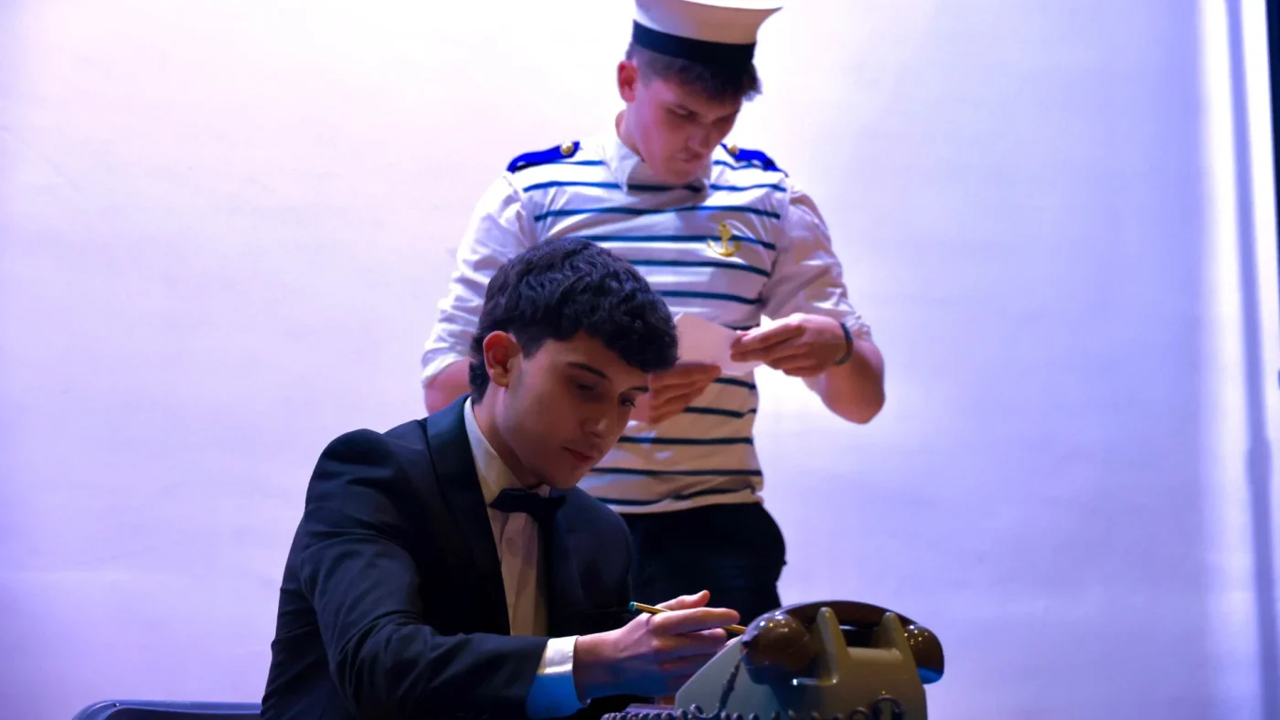 Two Barney students performing, with one in a suit and one dressed as a sailor.