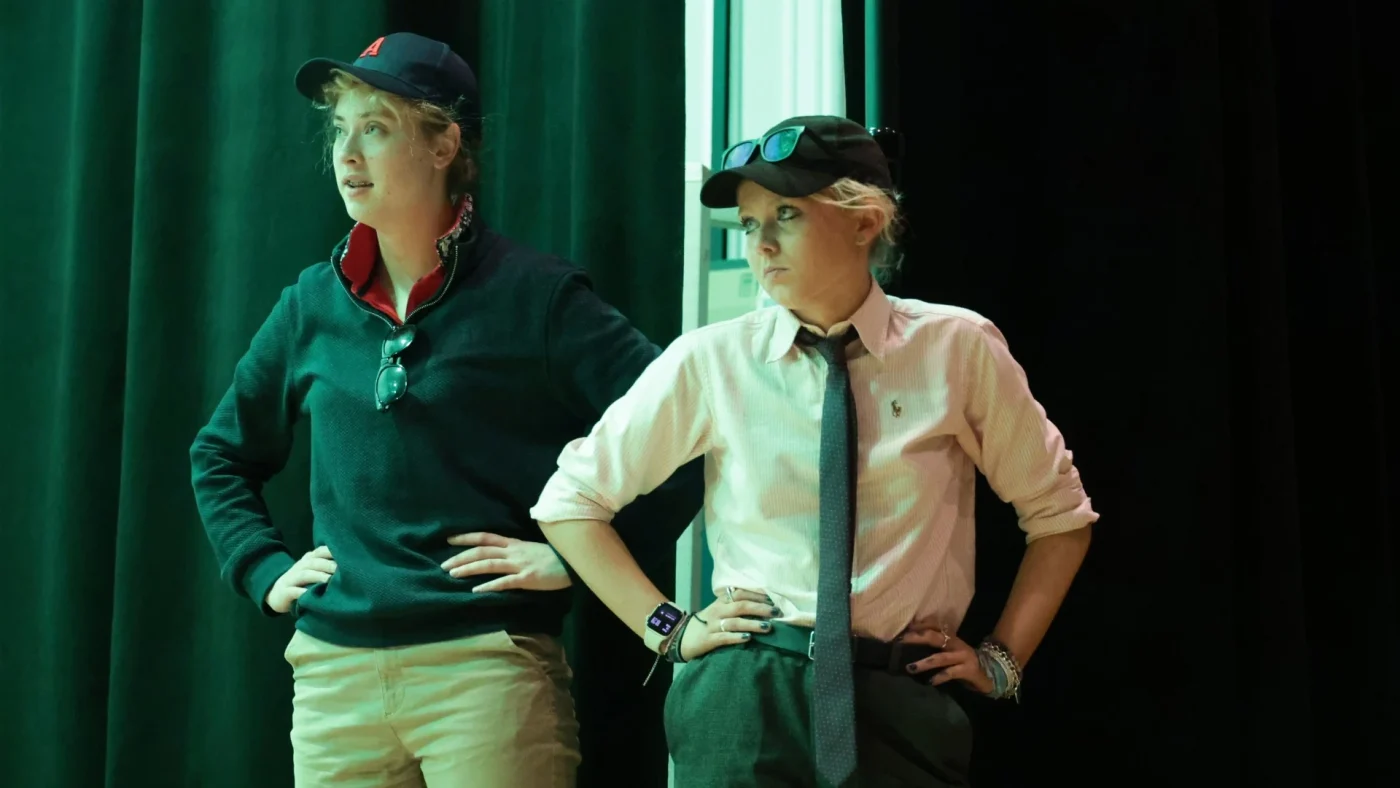 Two Barney students stood performing wearing caps.