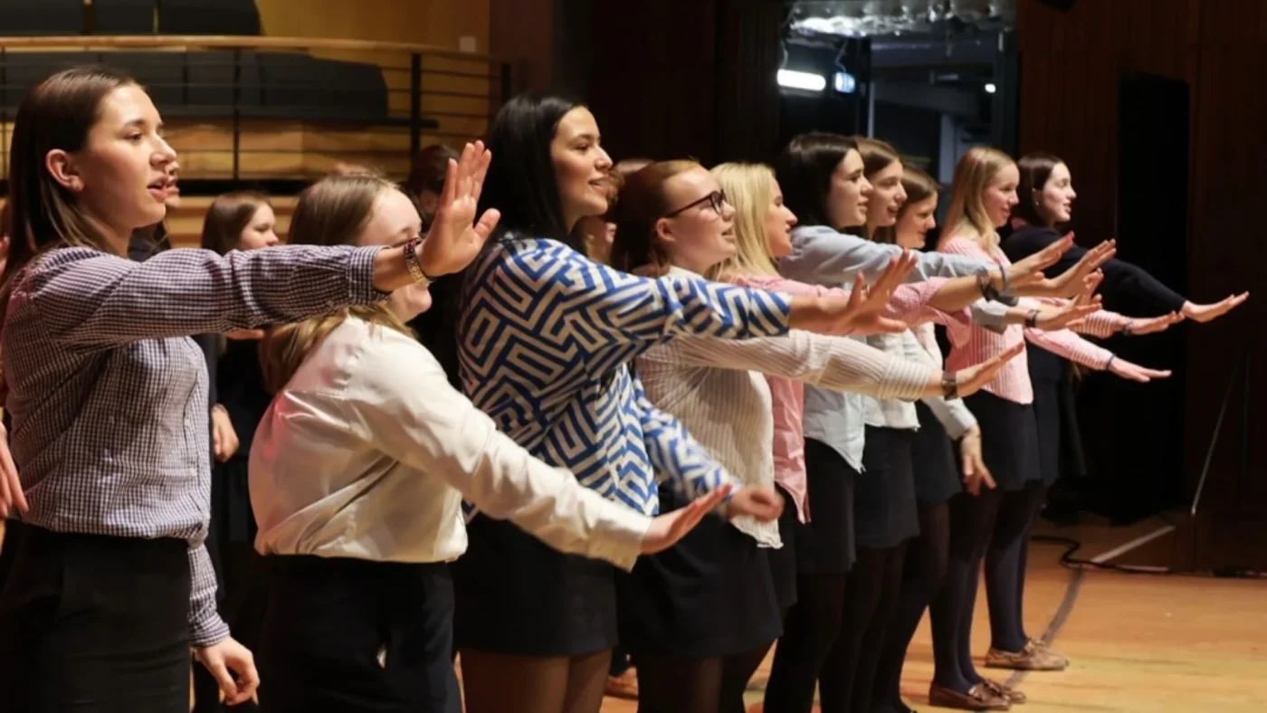 A row of Barney students performing a song at The Glasshouse.
