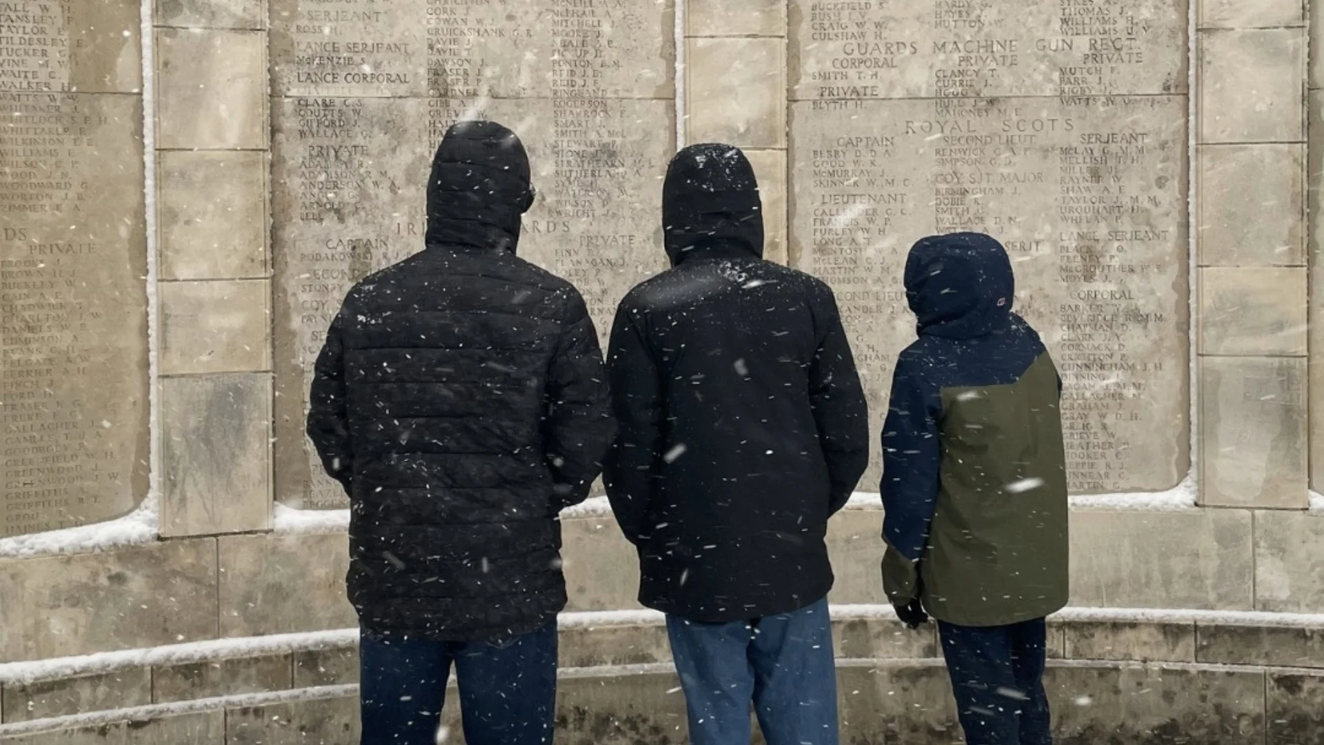 Three Barney students read the names on a WW1 monument.