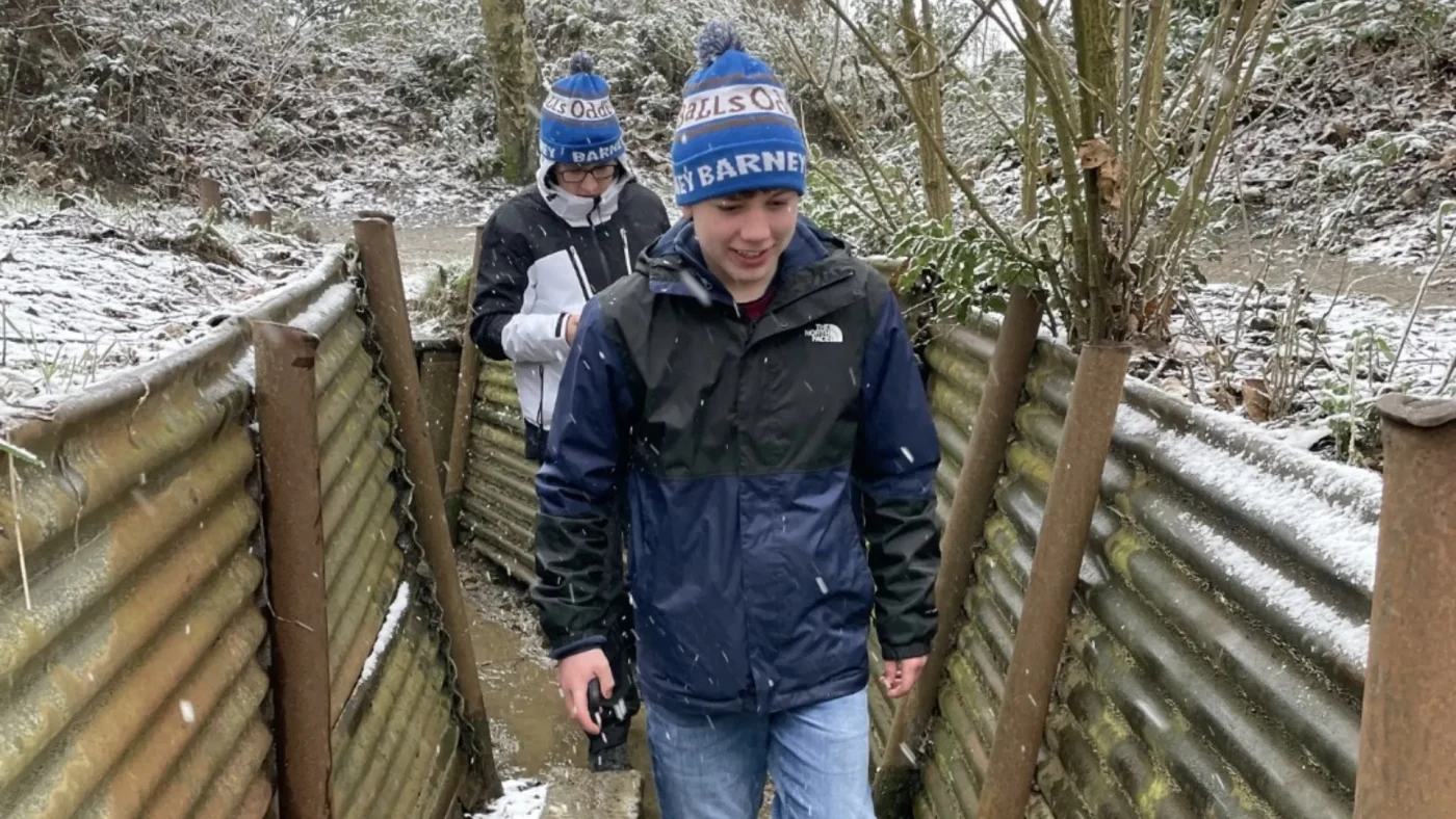 Two Barney students walking through trenches in the snow.