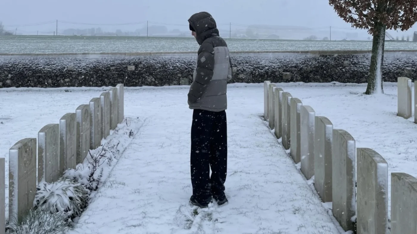 A Barney student standing alone in a snow-covered WW1 cemetery.