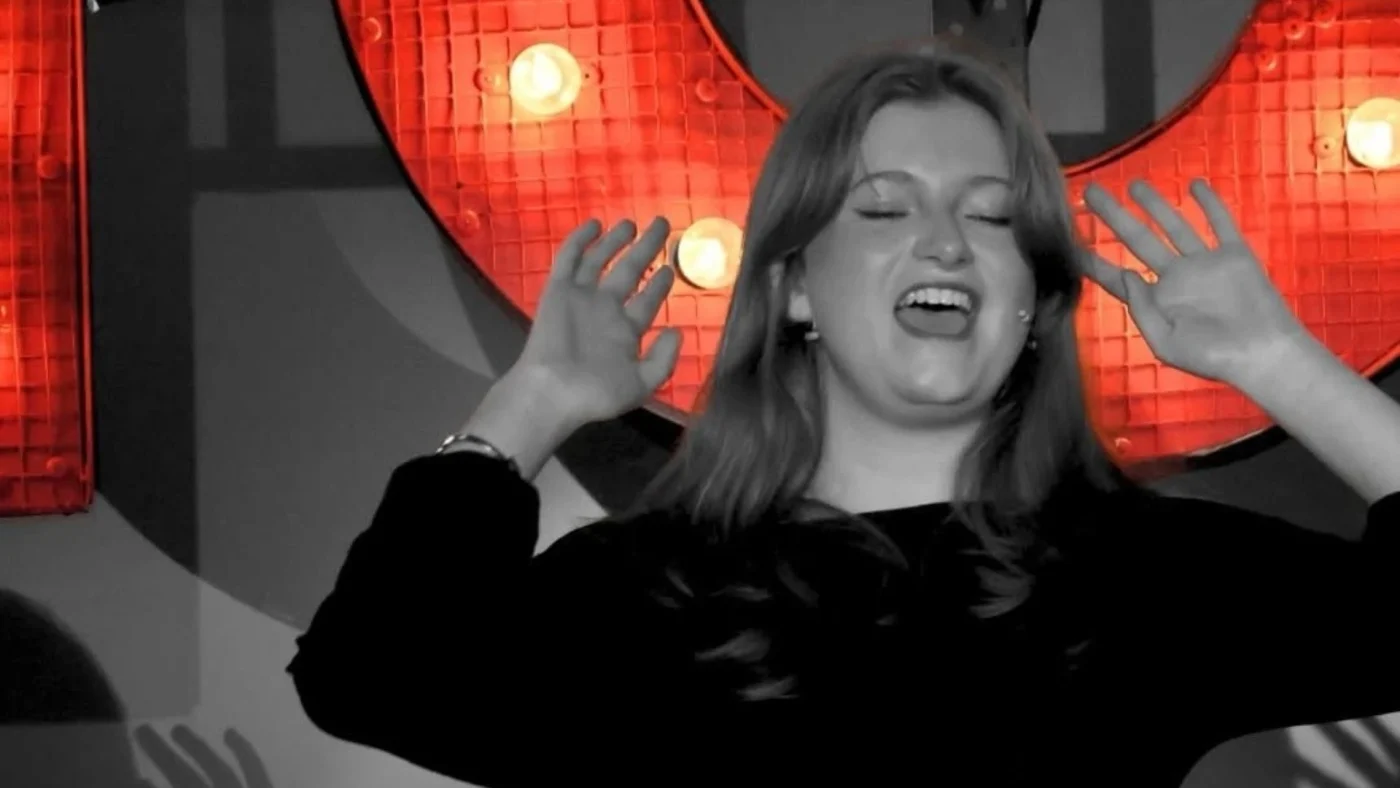 A Barney Senior School student singing in front of a large, lit sign that reads Chicago.