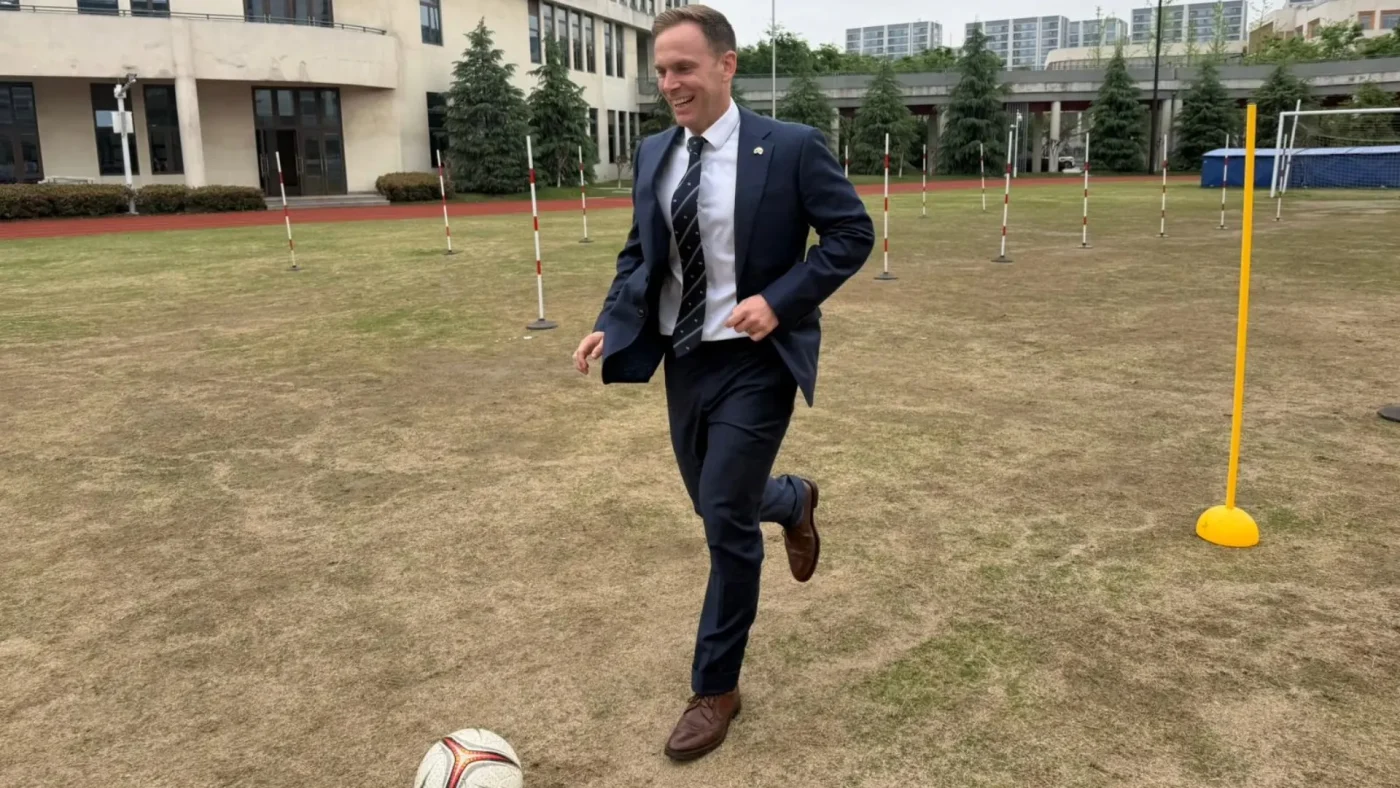 Barney Headmaster David Cresswell kicking a football.