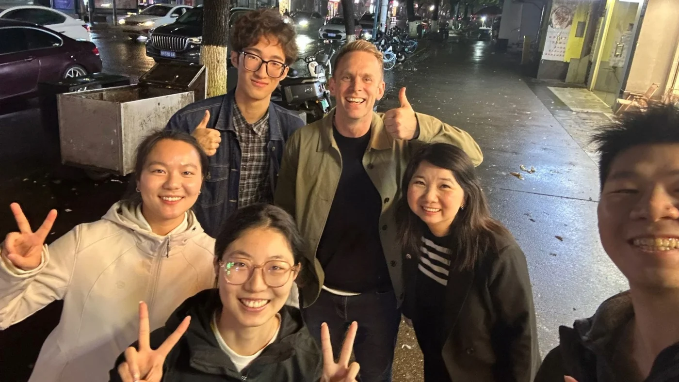 David Cresswell giving a thumbs up with a group of people on his China trip.