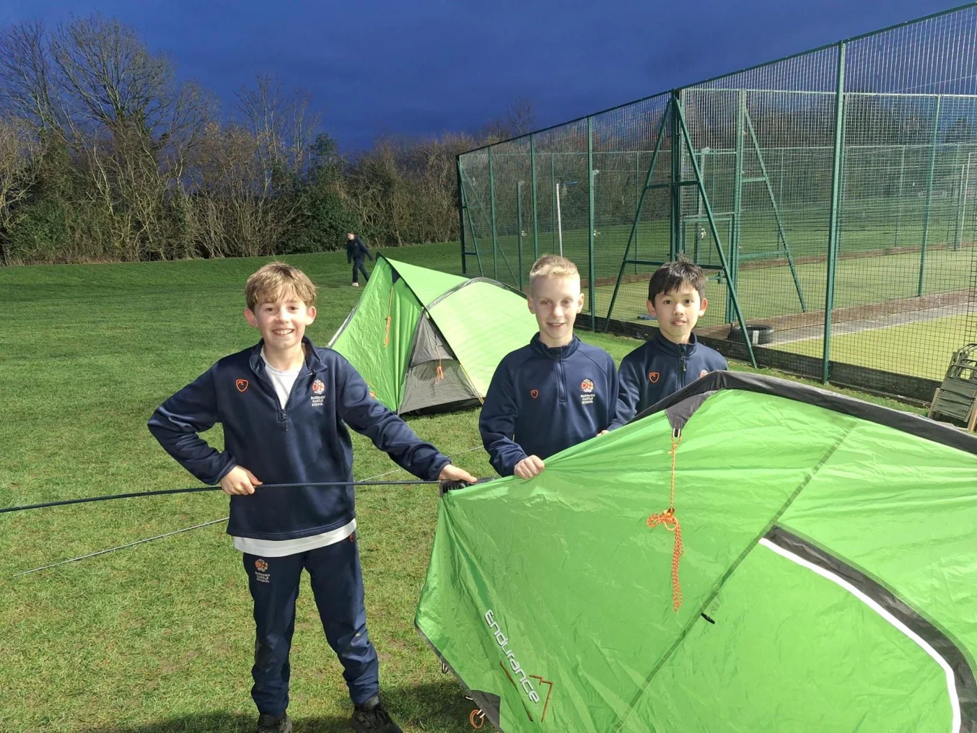 Three Barney pupils putting up a tent.