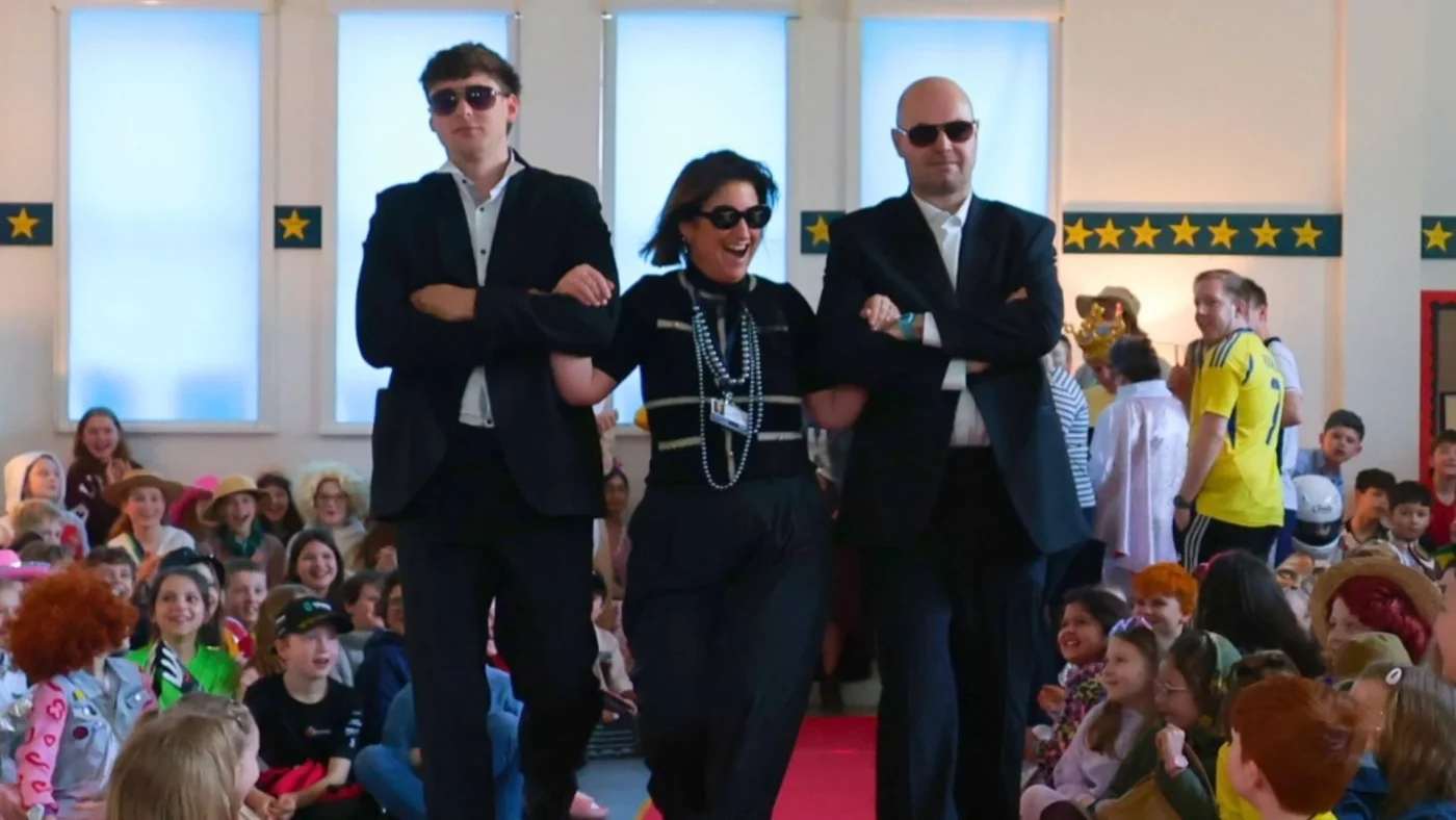 Barney teachers walking down the catwalk in fancy dress for World Book Day.
