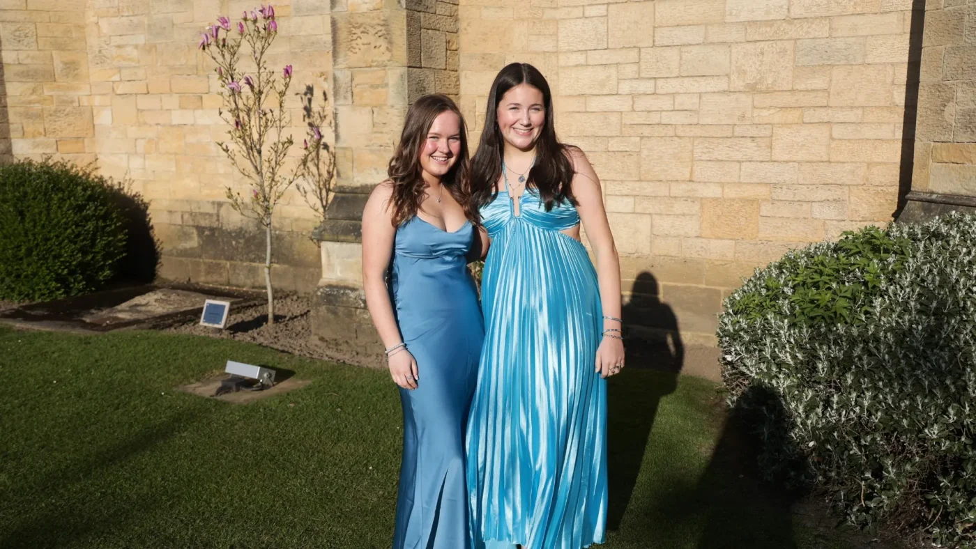 Two Longfield Girls’ Boarding House members in blue dresses.