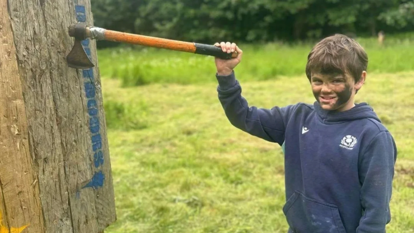 A Year 5 Barney pupil pulling a hatchet from a wooden board.
