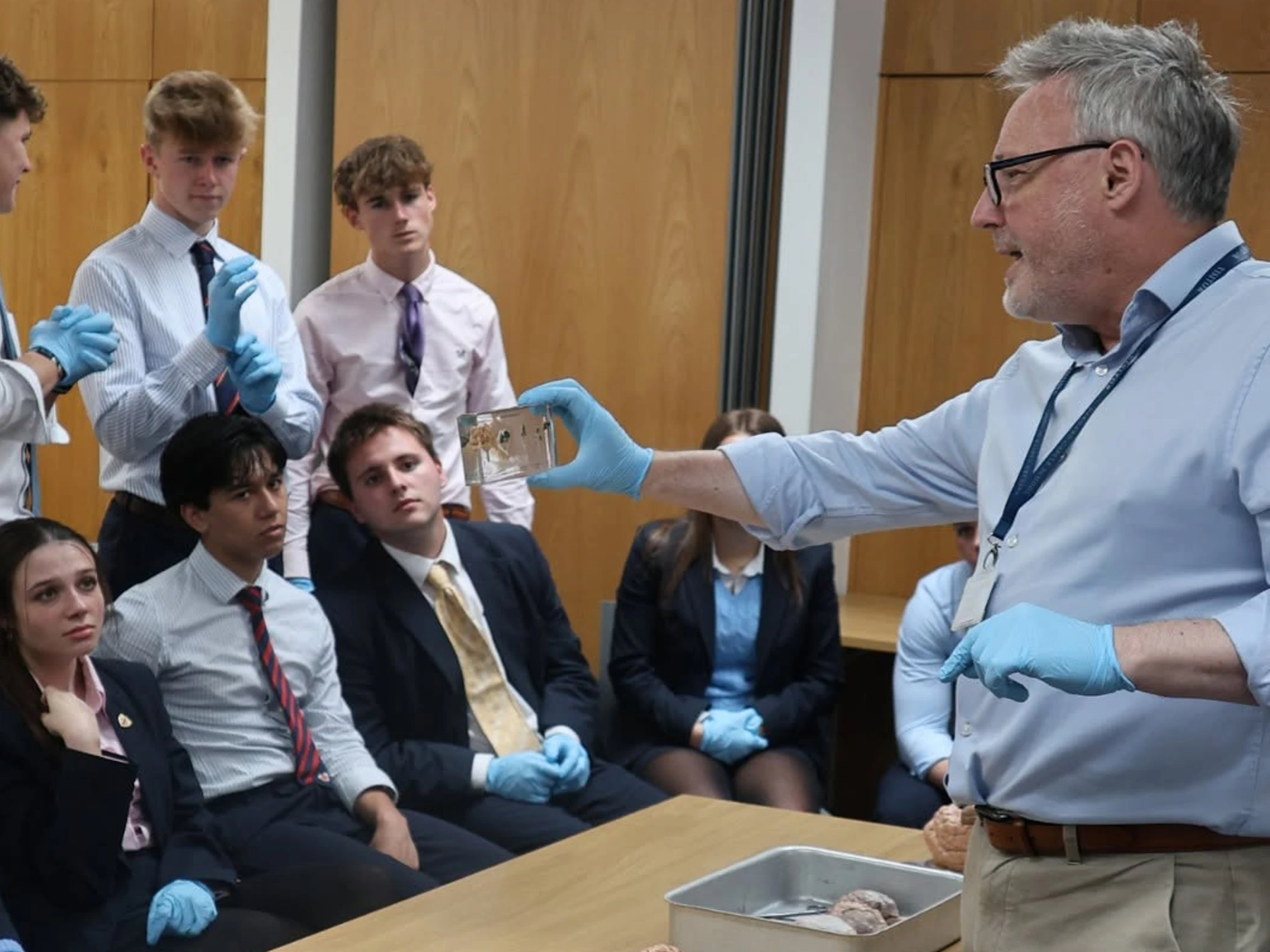 Dr Sutton holds up glass display of brains to class during Brain Day session.