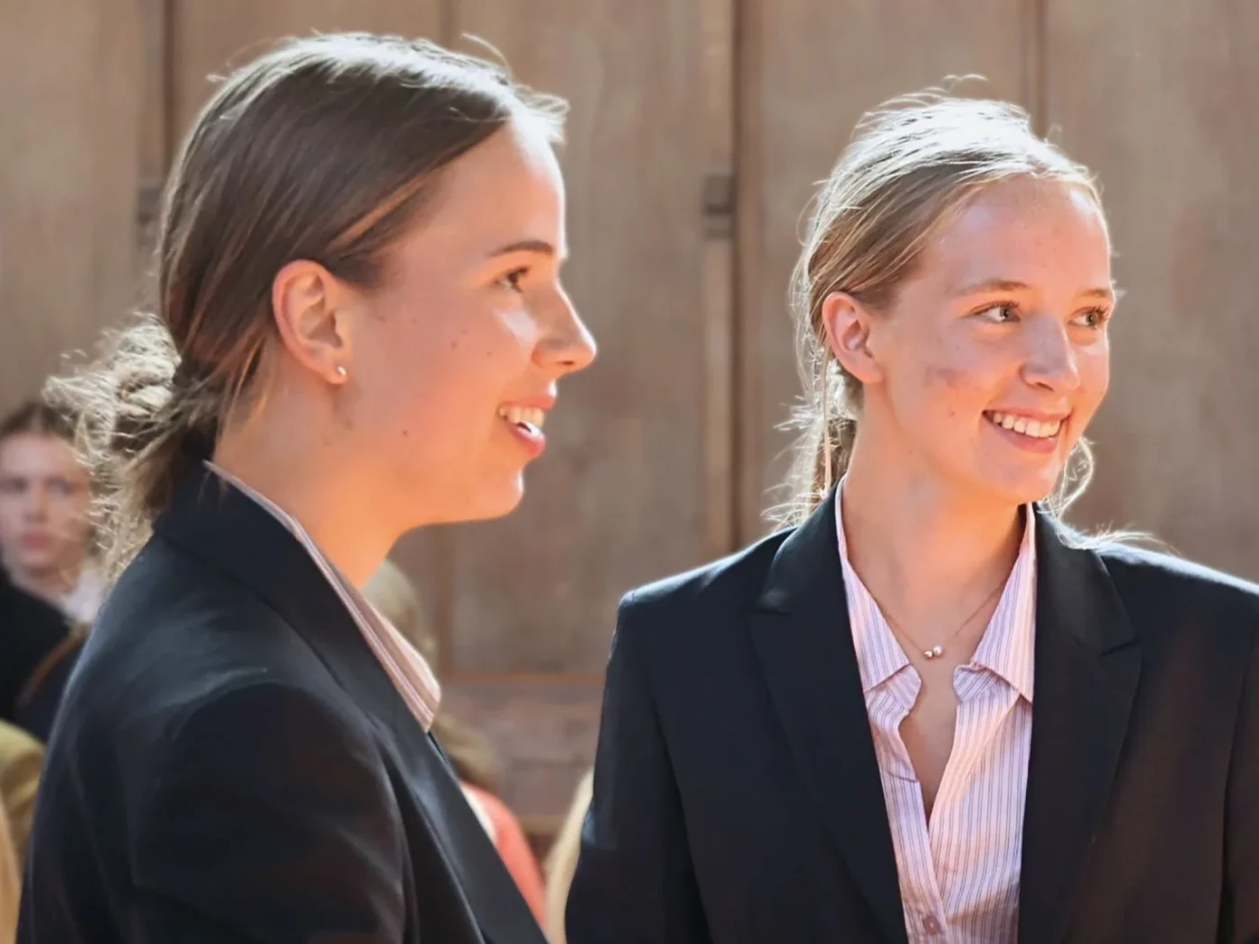 Two girls smiling during prize giving ceremony.