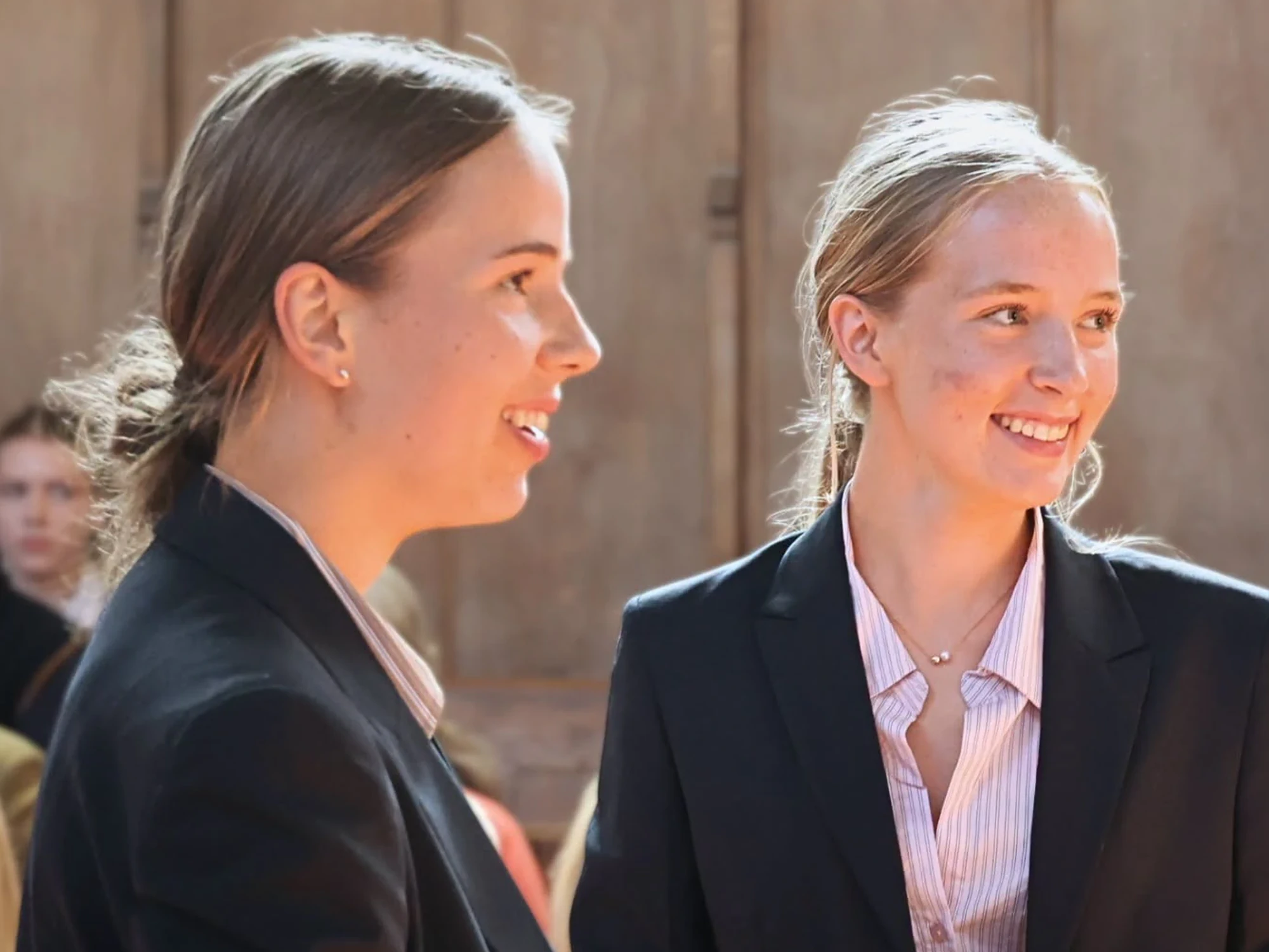 Two girls smiling during prize giving ceremony.