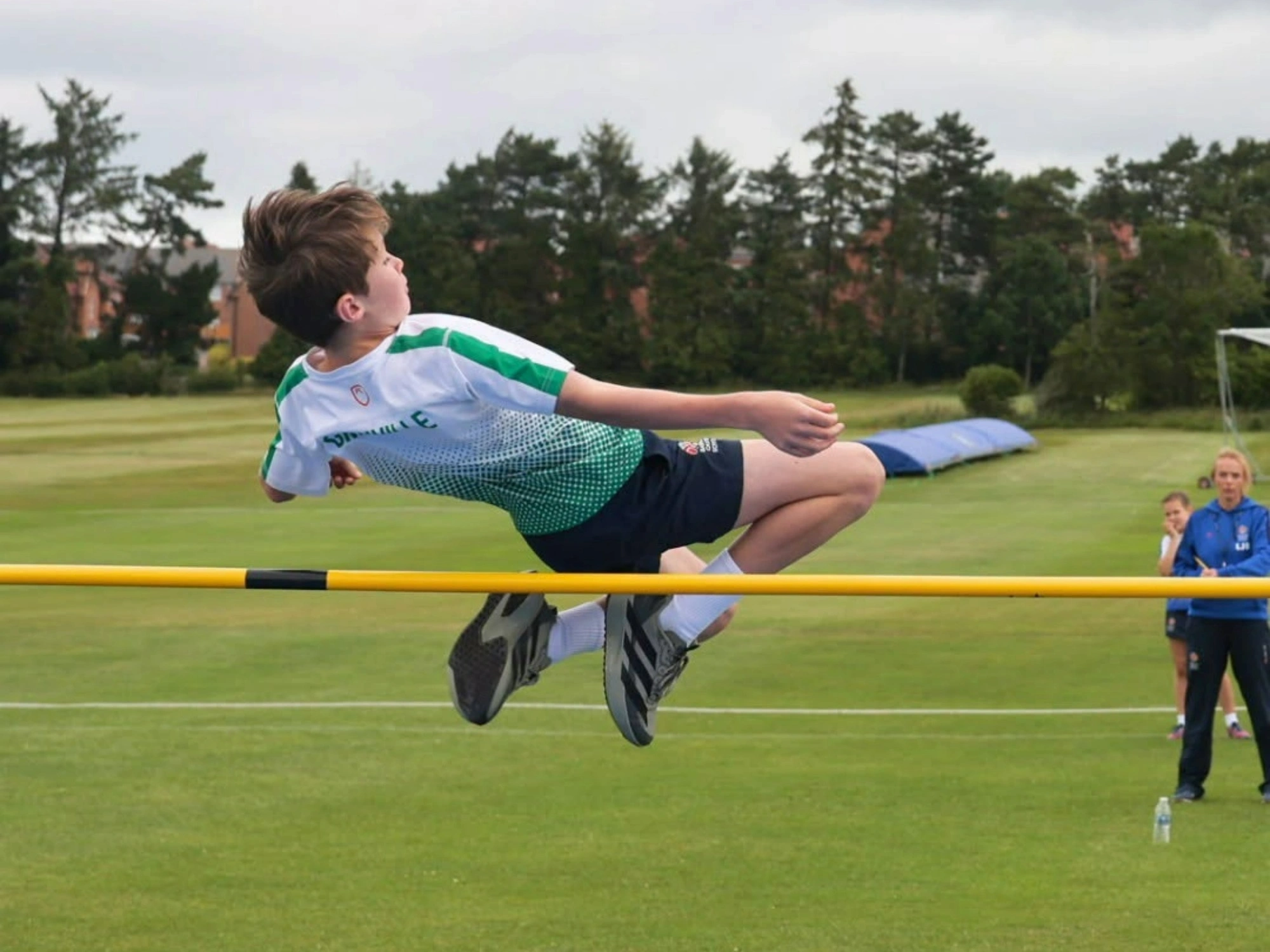 A Prep School student mid-air during high jump event at sports day