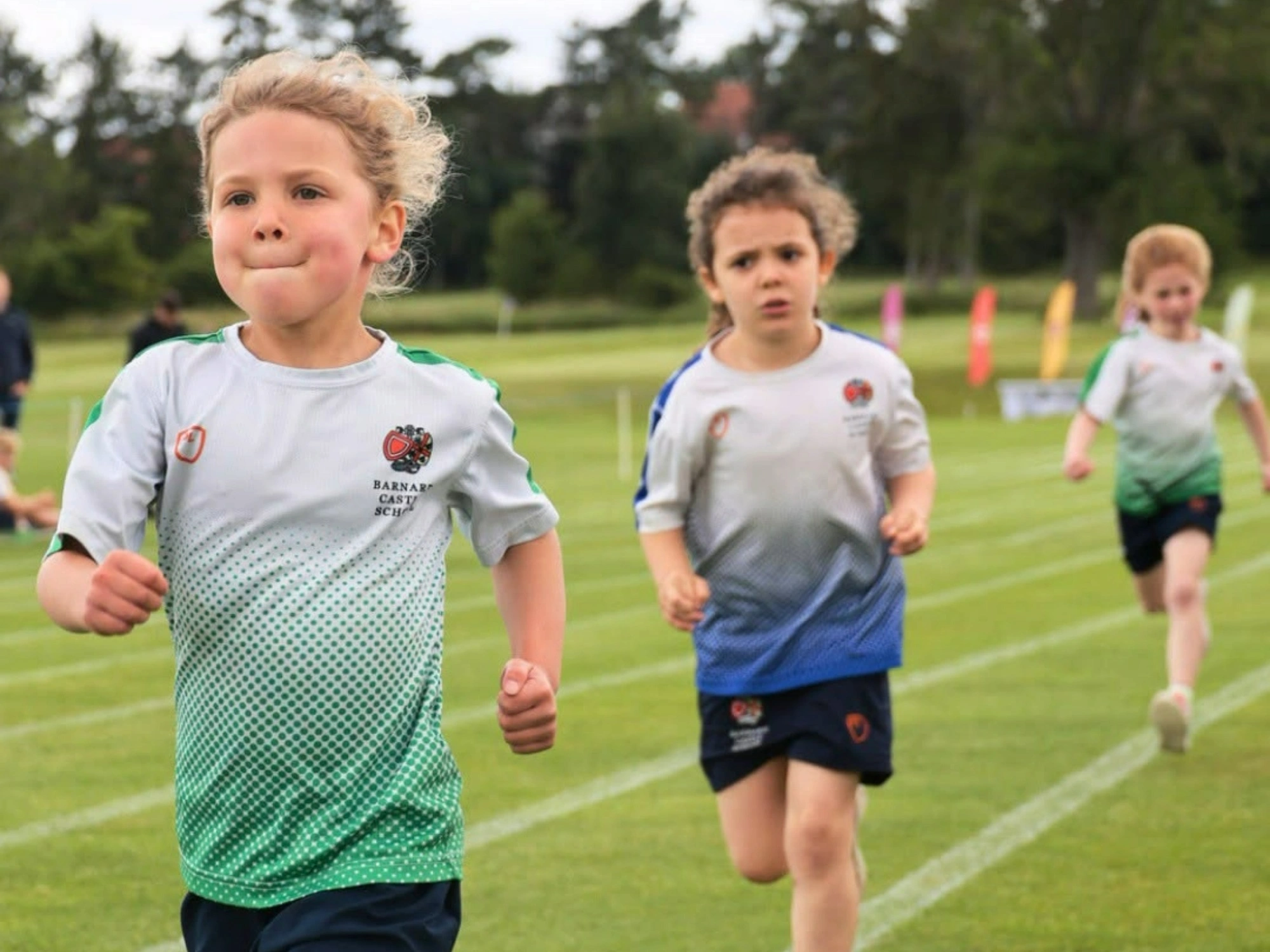 Young Barney students running around track on sports day.