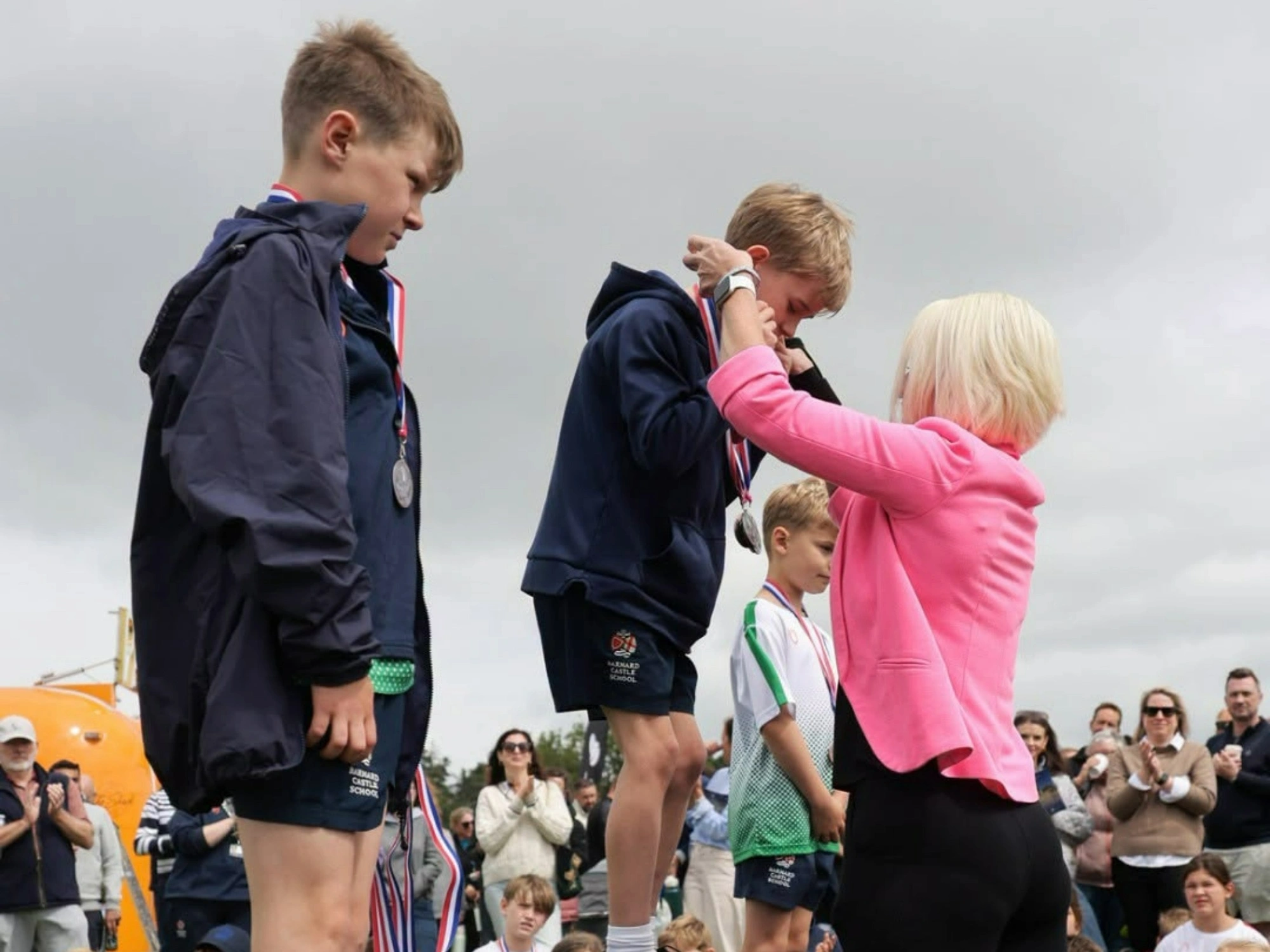 Prep School students on podium receiving medals on sports day.