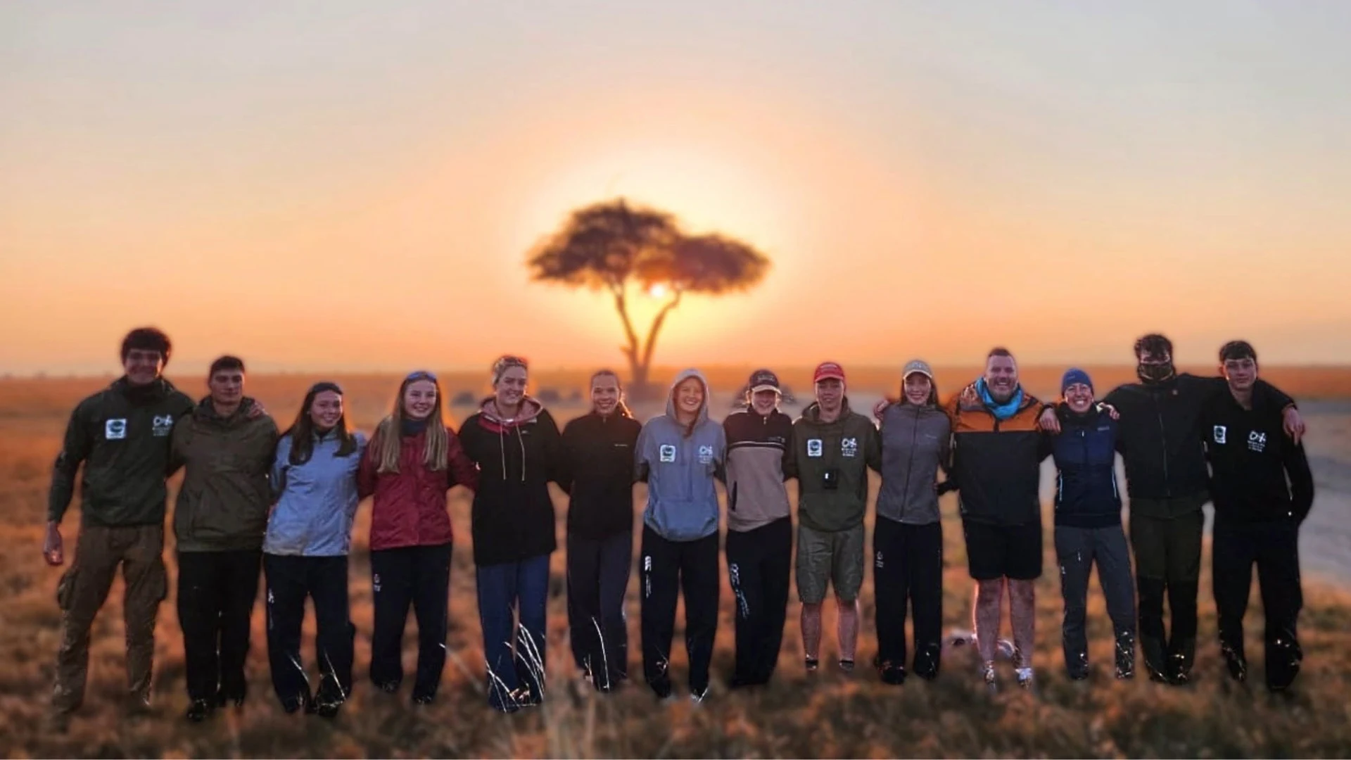 A large group of Barney students on the African savanna.