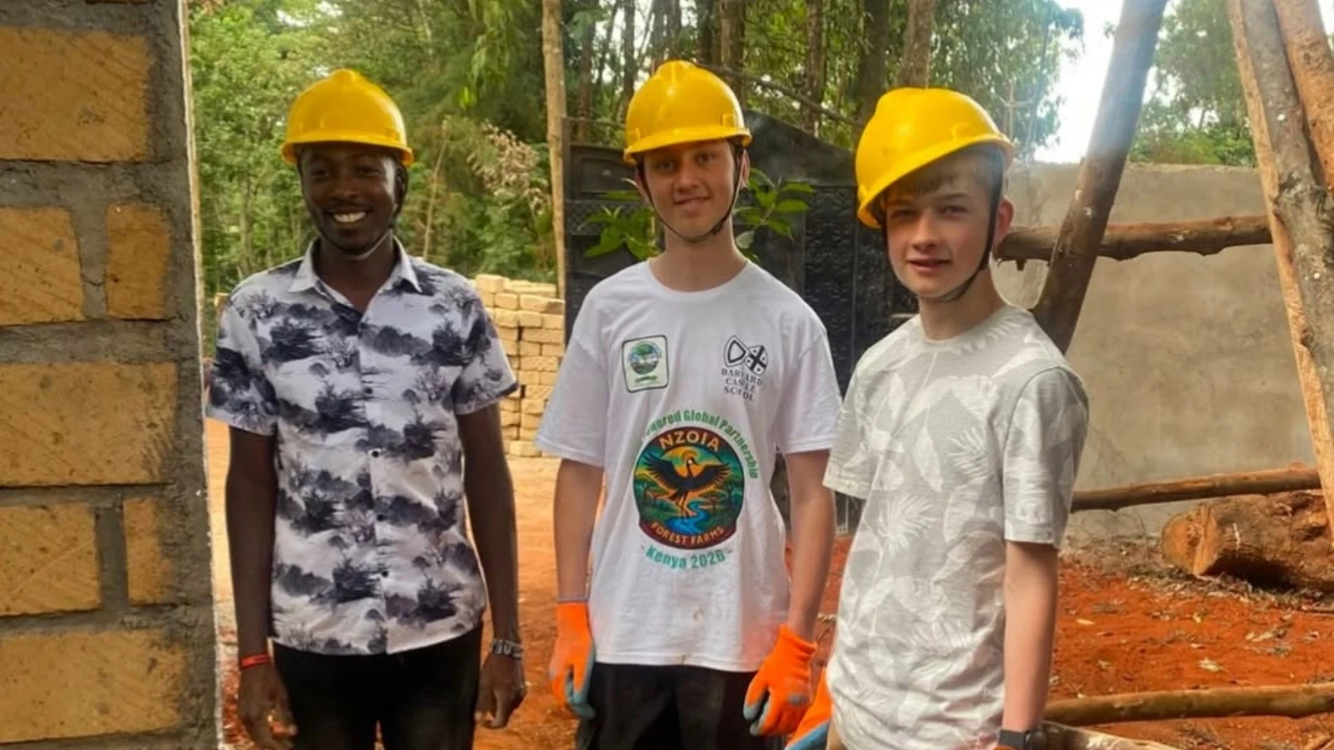 Three Barney students in yellow hard hats on the Kenya expedition.